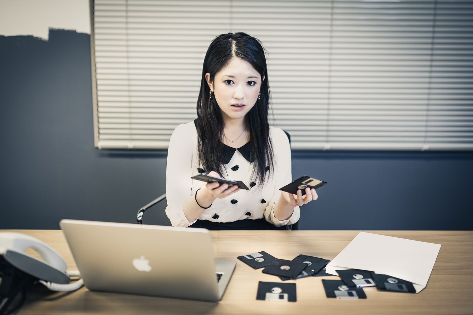 パソコンにフロッピーディスクが入らず顔面蒼白になる経理｜ぱくたそフリー素材