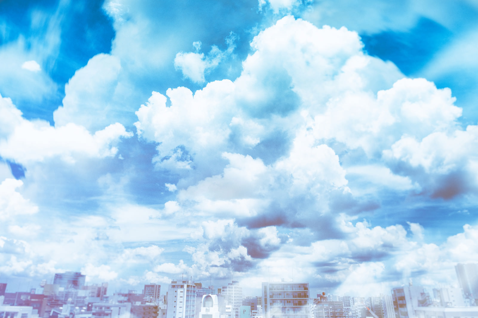 「建物の頭上にある絵に描いたような雲 | フリー素材のぱくたそ」の写真