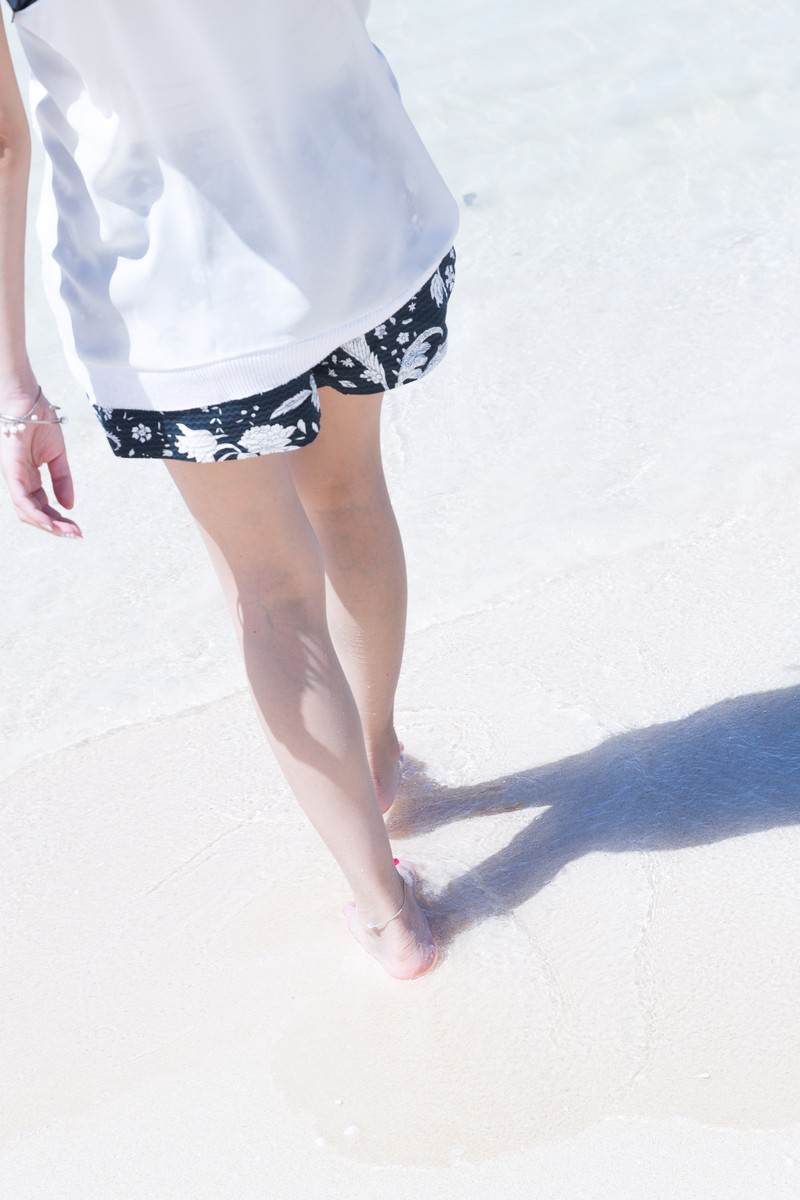 「水辺を歩く女性の足元 | フリー素材のぱくたそ」の写真