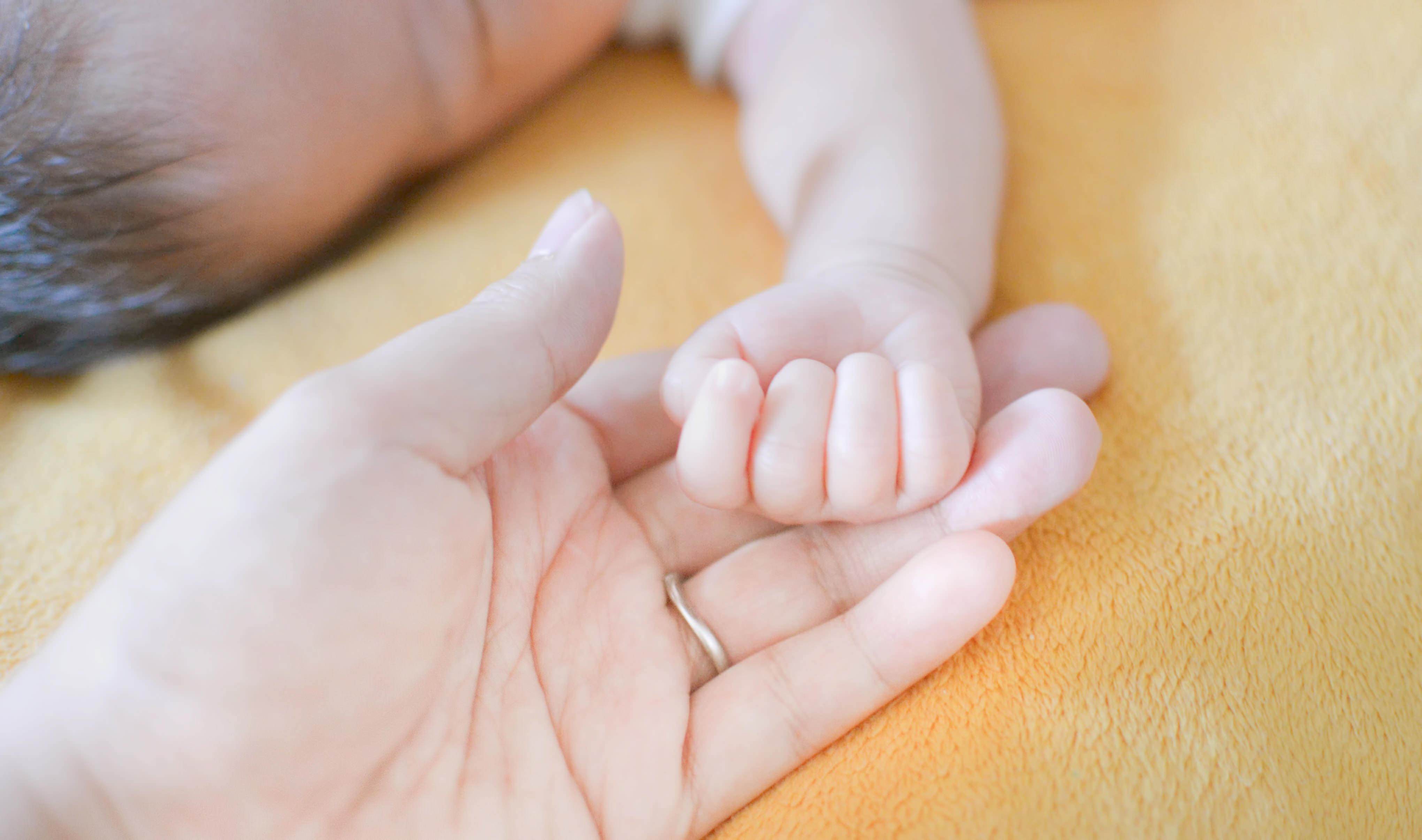 新生児と親の手の写真（画像）｜フリー素材「ぱくたそ」