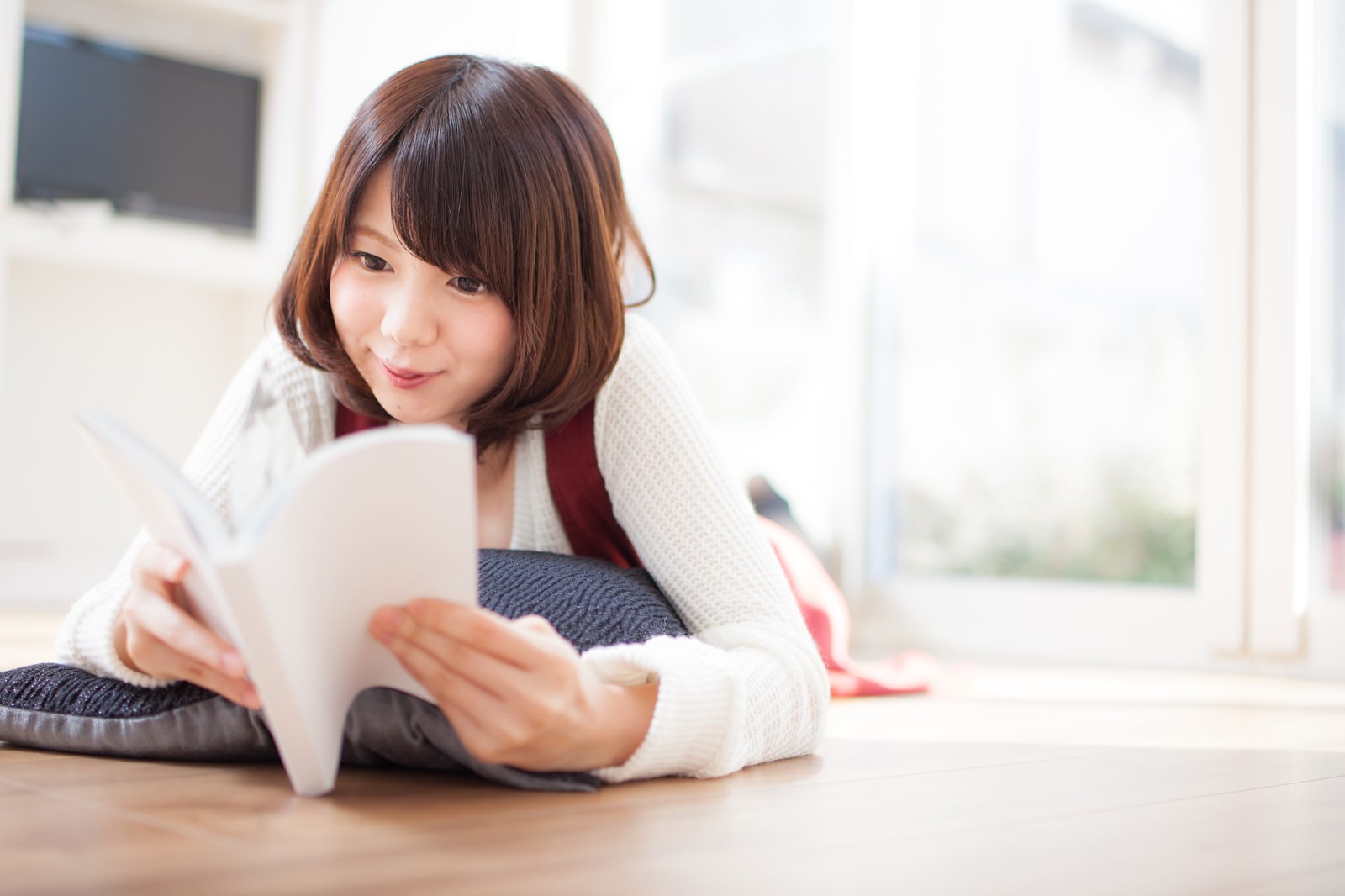 「マンガのワクワクする展開に思わず笑みがこぼれる女性マンガのワクワクする展開に思わず笑みがこぼれる女性」［モデル：みき。］のフリー写真素材を拡大