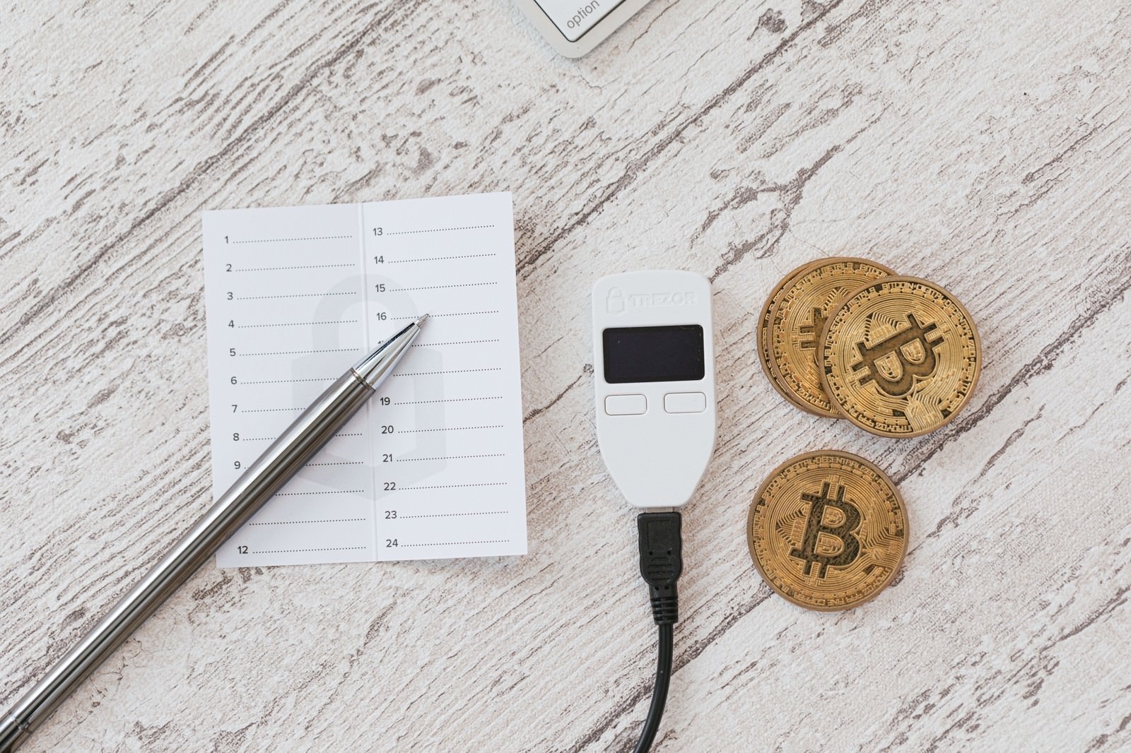 「メモ書きと並べたTREZORとビットコイン | フリー素材のぱくたそ」の写真