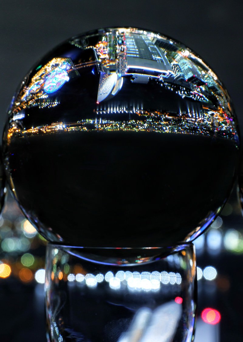 「水晶玉に映り込む都会の夜景」の写真