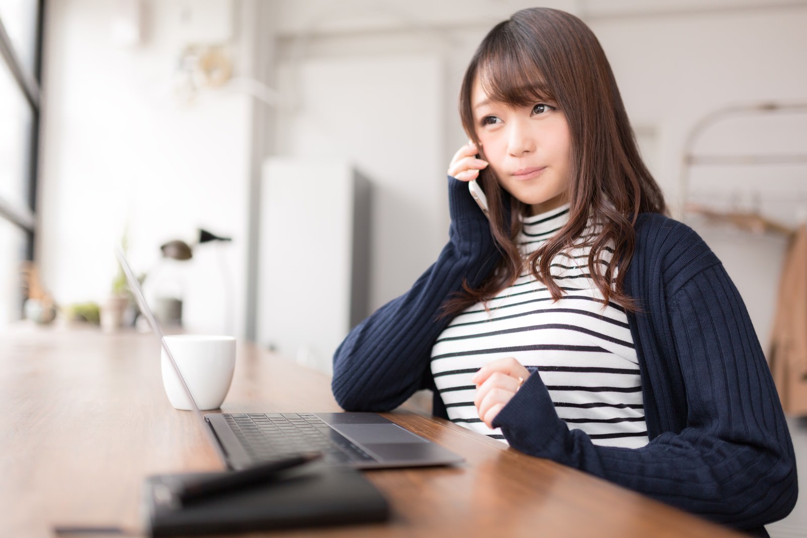 朗報に笑顔が溢れるボーダー柄の服を着た女性の写真素材 ぱくたそ