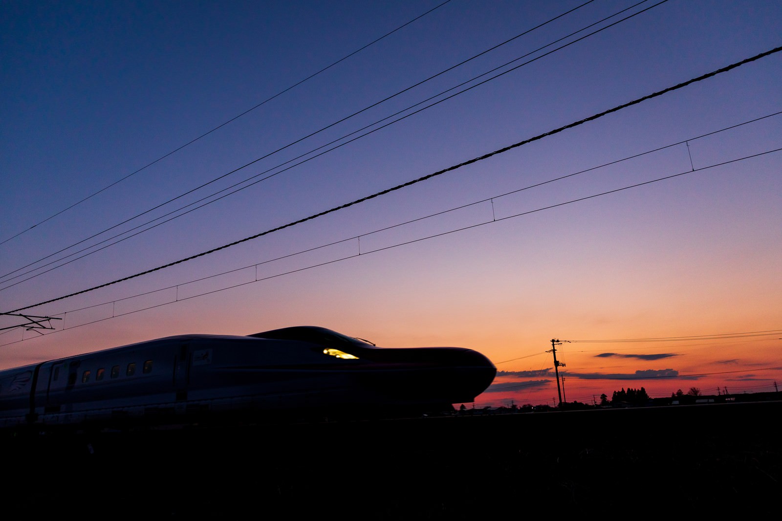 「夕焼け空と特別急行列車E6系こまちのシルエット」の写真