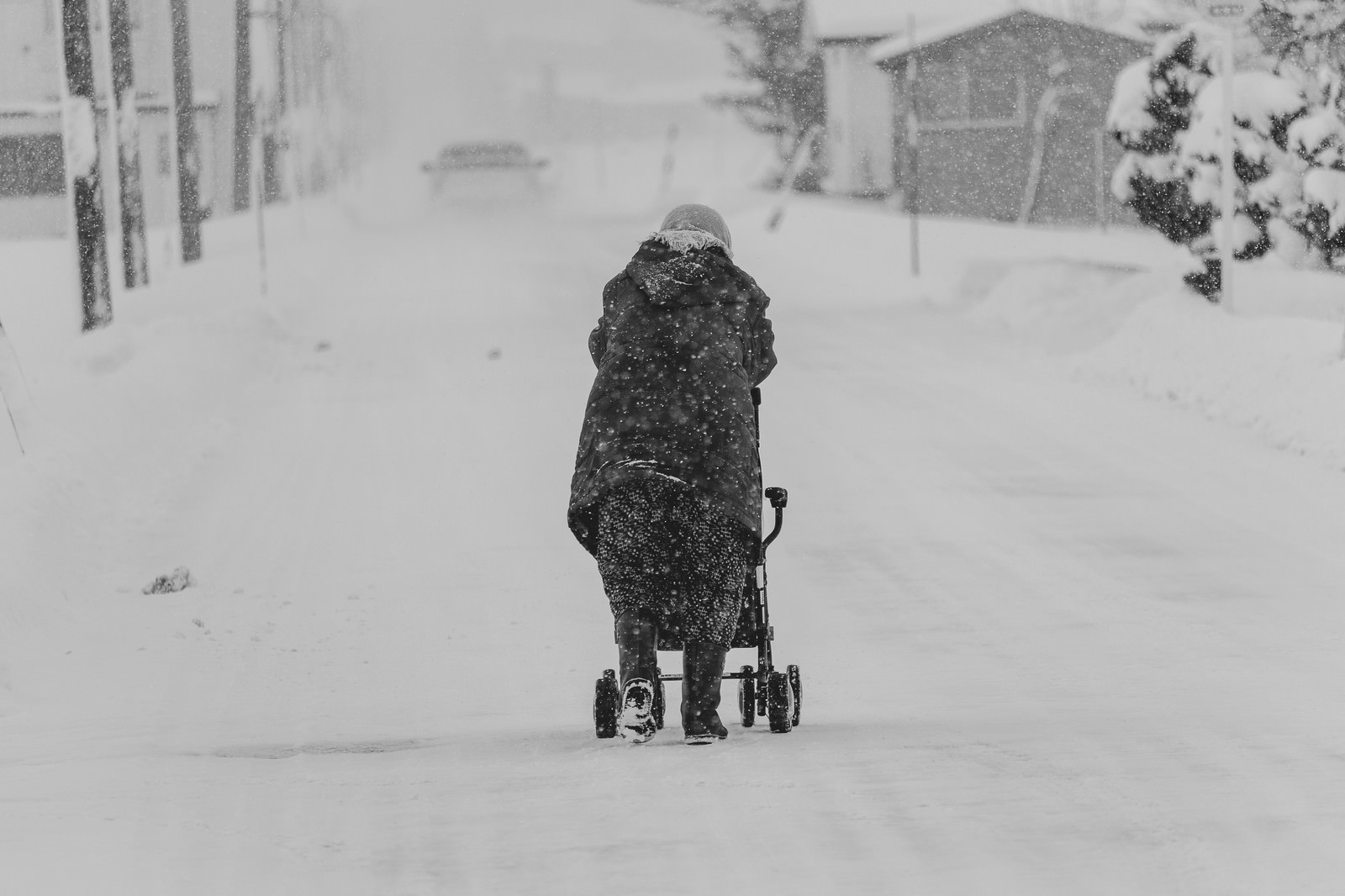 「雪が降る中、移動する豪雪地帯に住む高齢者」の写真