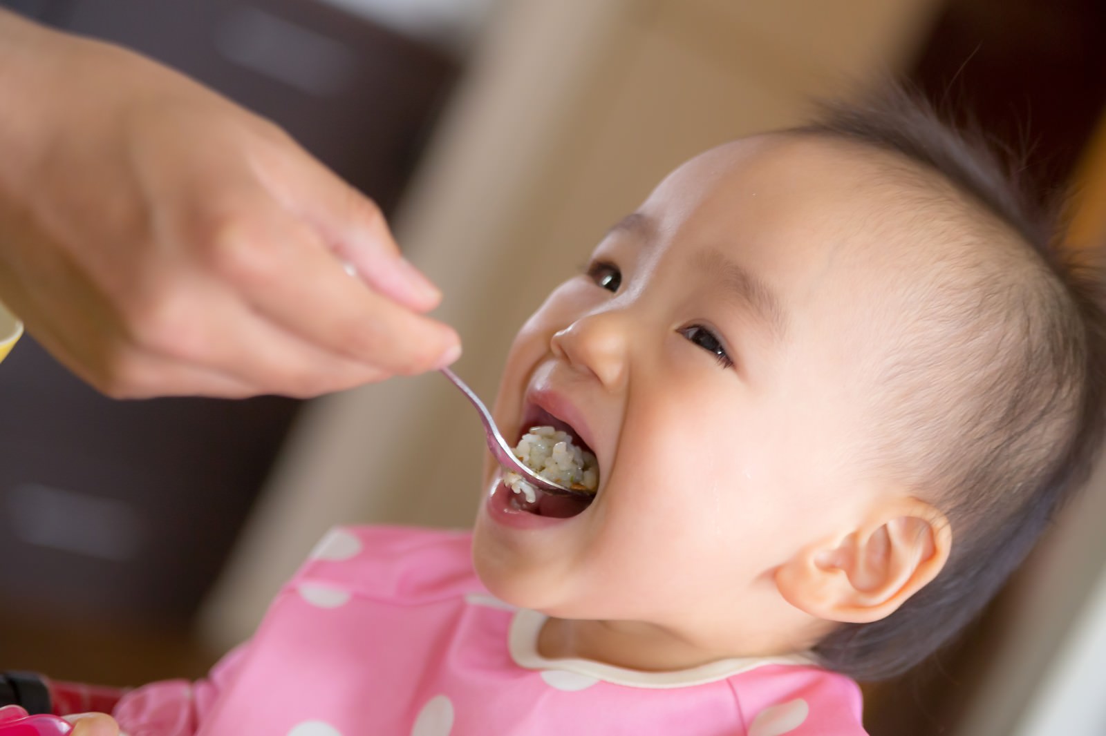 大きなお口でご飯をあーんする赤ちゃんのフリー素材