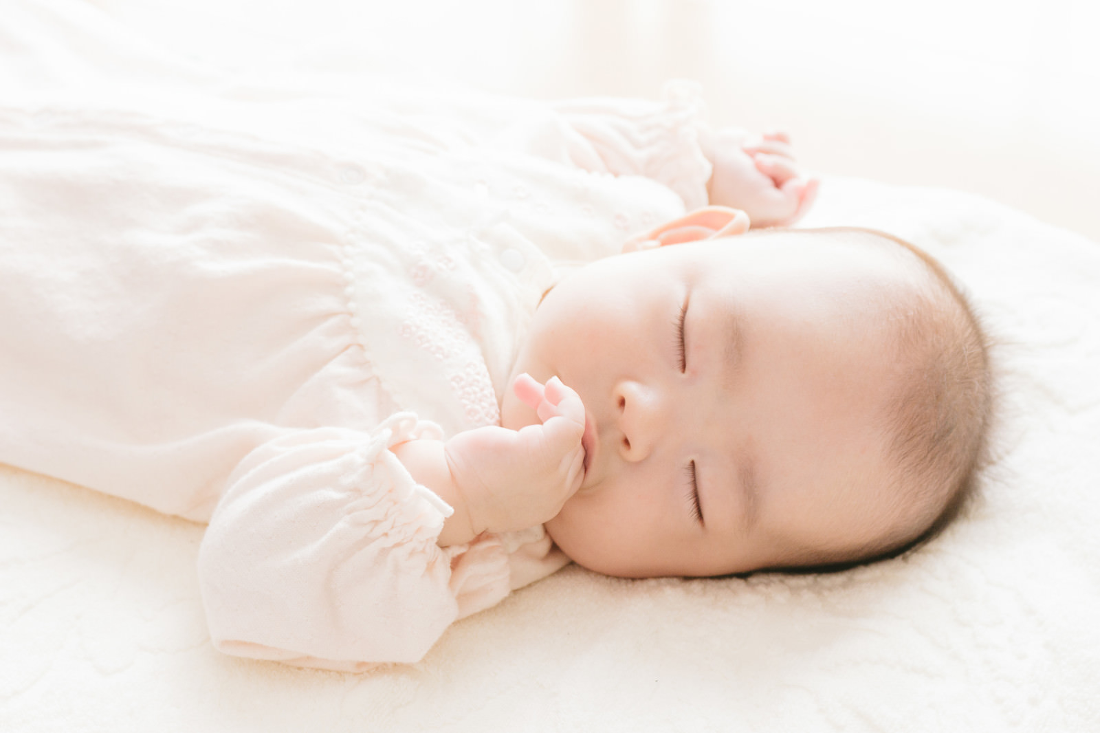 「指を咥える新生児」の写真