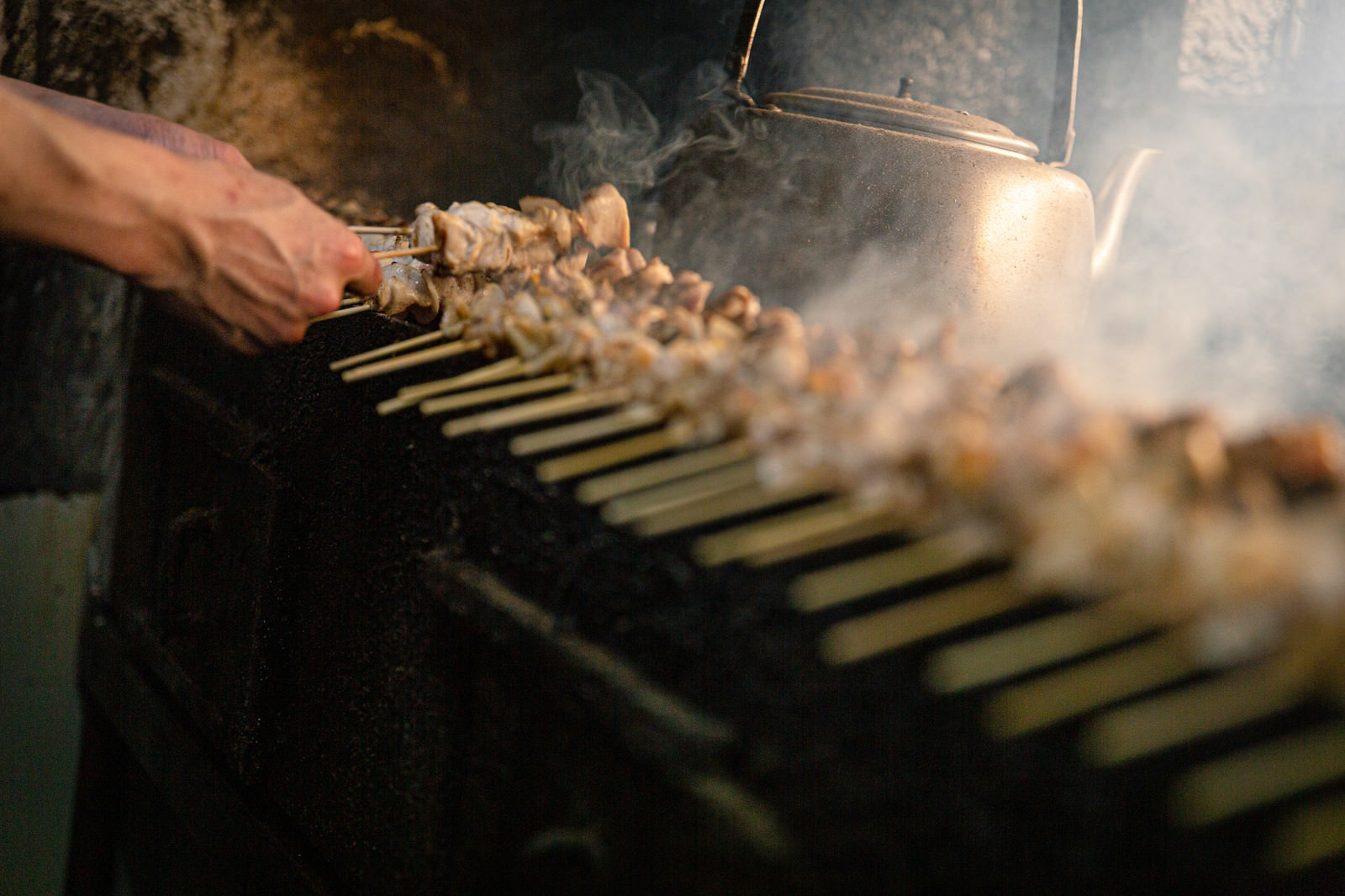 「一度に何本もの鳥串を焼く美唄焼き鳥の老舗店 | フリー素材のぱくたそ」の写真