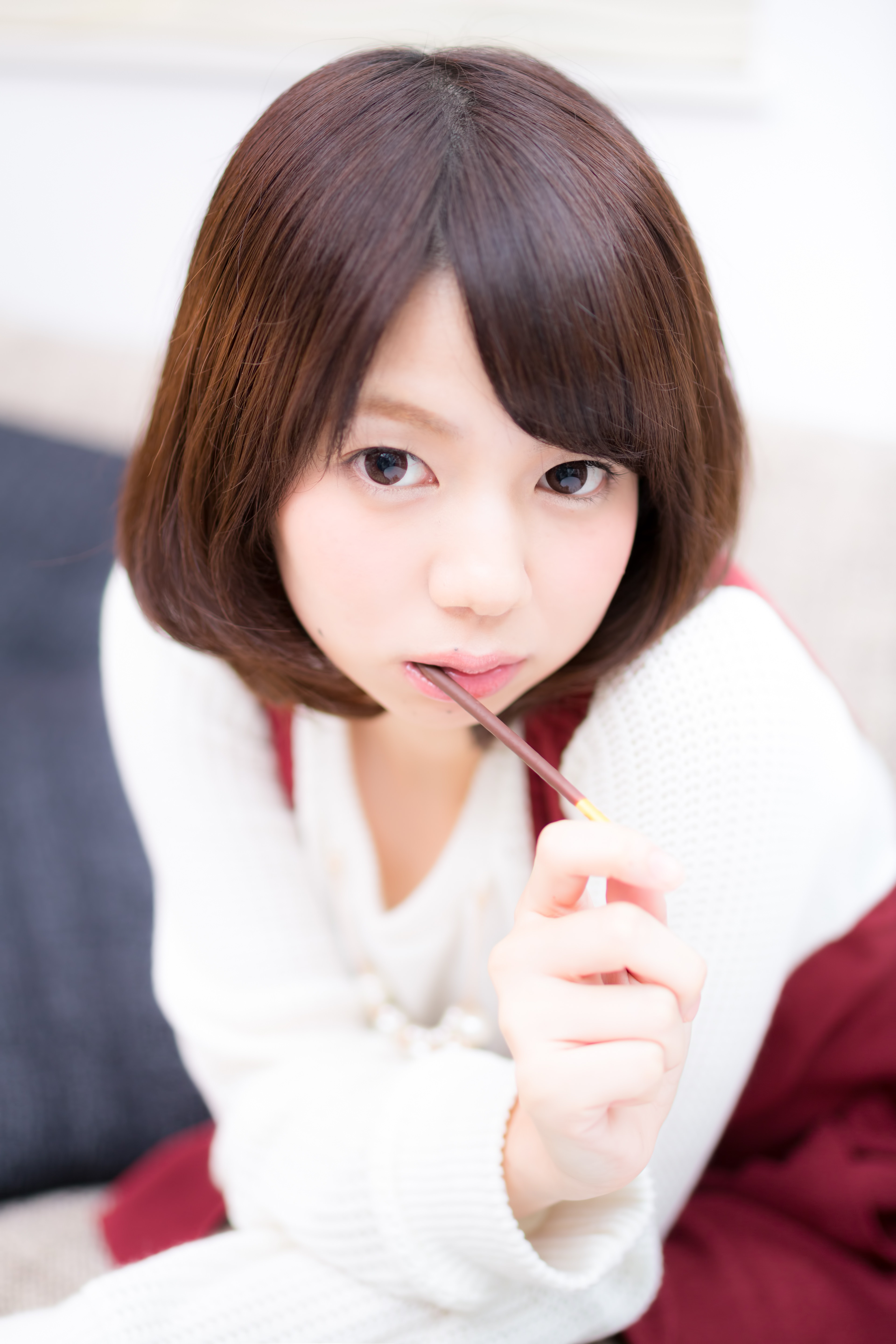 おやつを食べながら上目遣いの彼女の写真素材 ぱくたそ