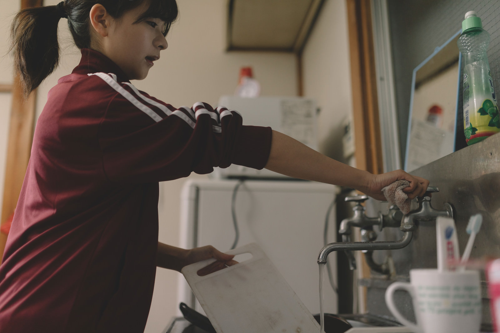 「溜まった洗い物をする貧乏学生（アパート暮らし）」の写真［モデル：千歳］