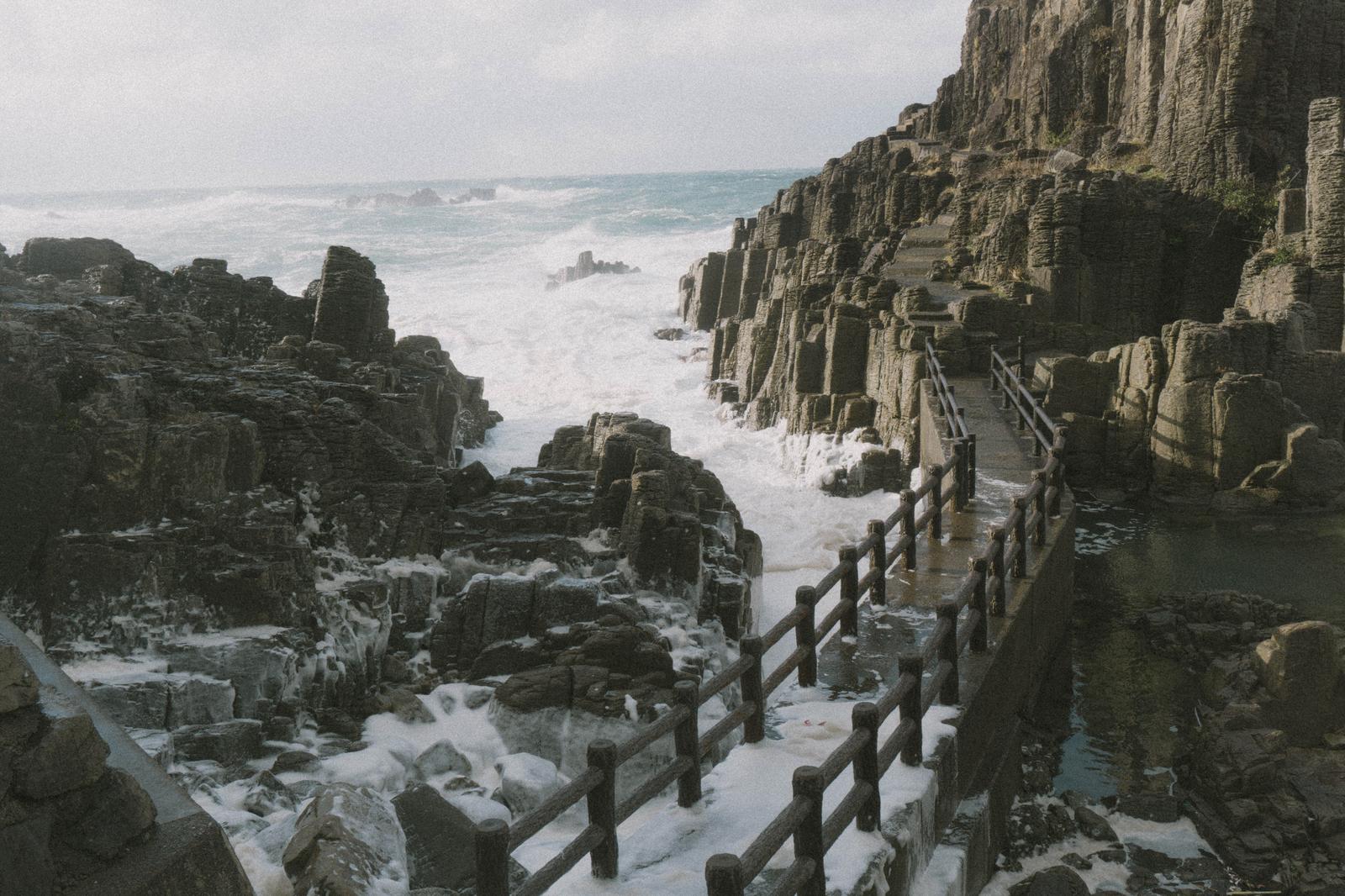 荒れた海が咲かせる波の花が寄せる日本海の岩場や歩道 - ぱくたそ