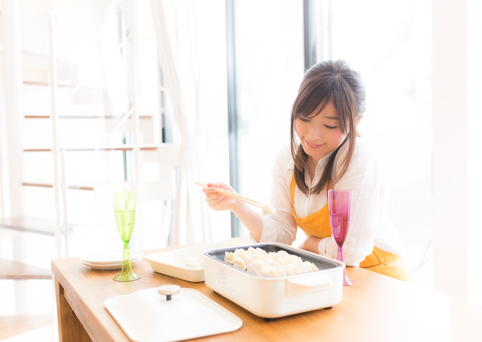 ホットプレートで餃子を焼く女性の写真 画像 フリー素材 ぱくたそ