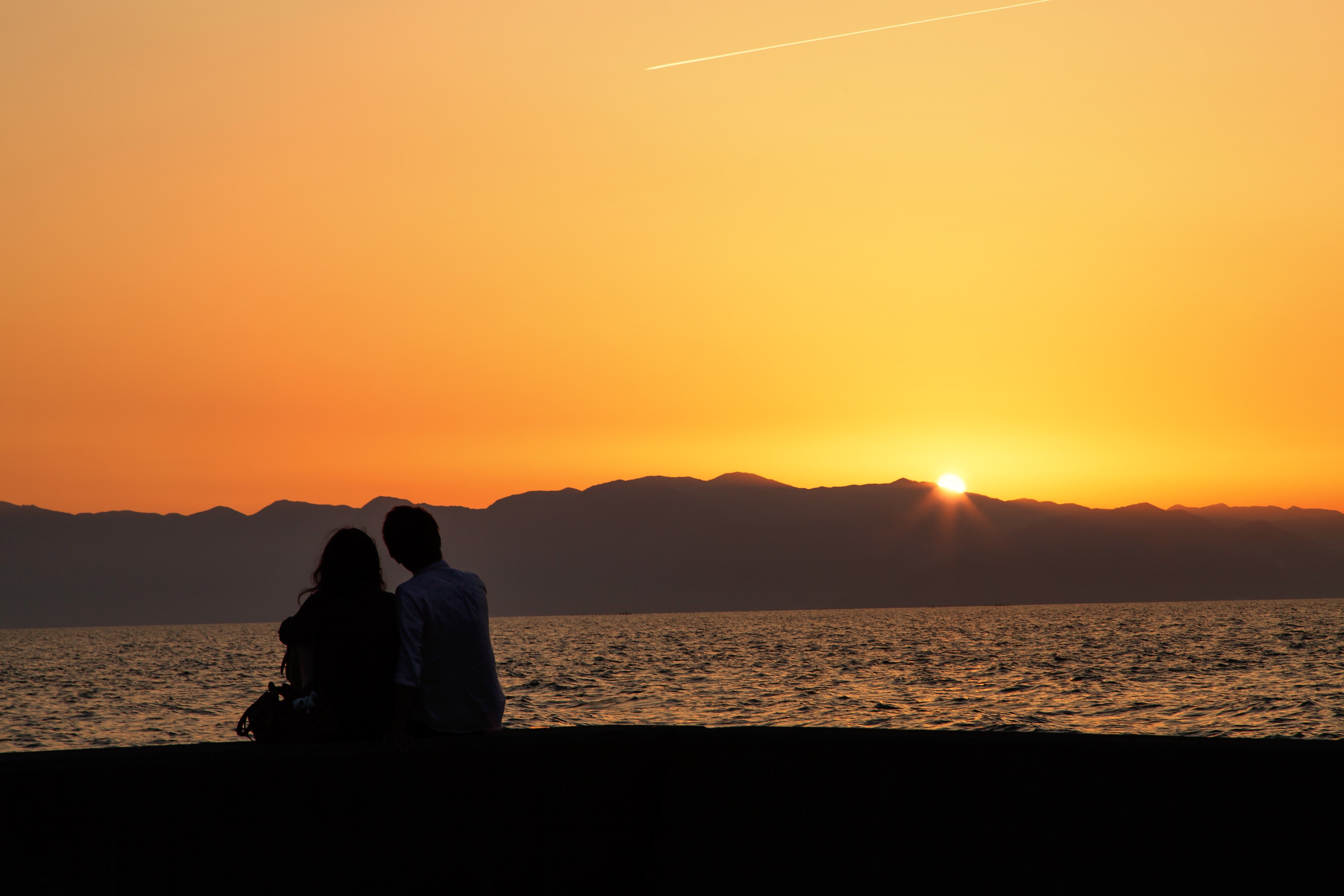 夕暮れとカップル フリー素材のぱくたそ