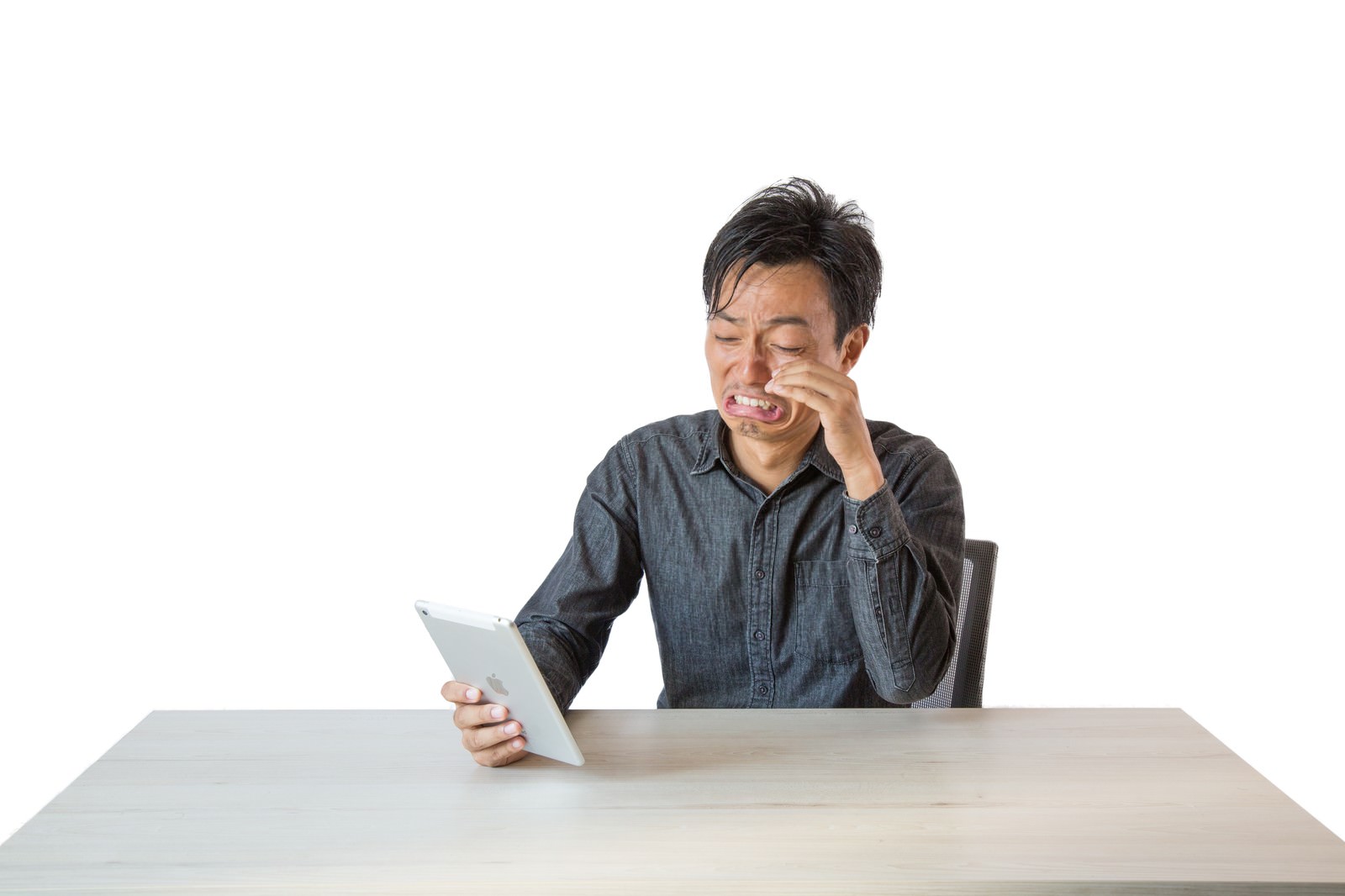 「タイムライン上に流れてきた感動エピソードに号泣する男性」の写真［モデル：藤沢篤］