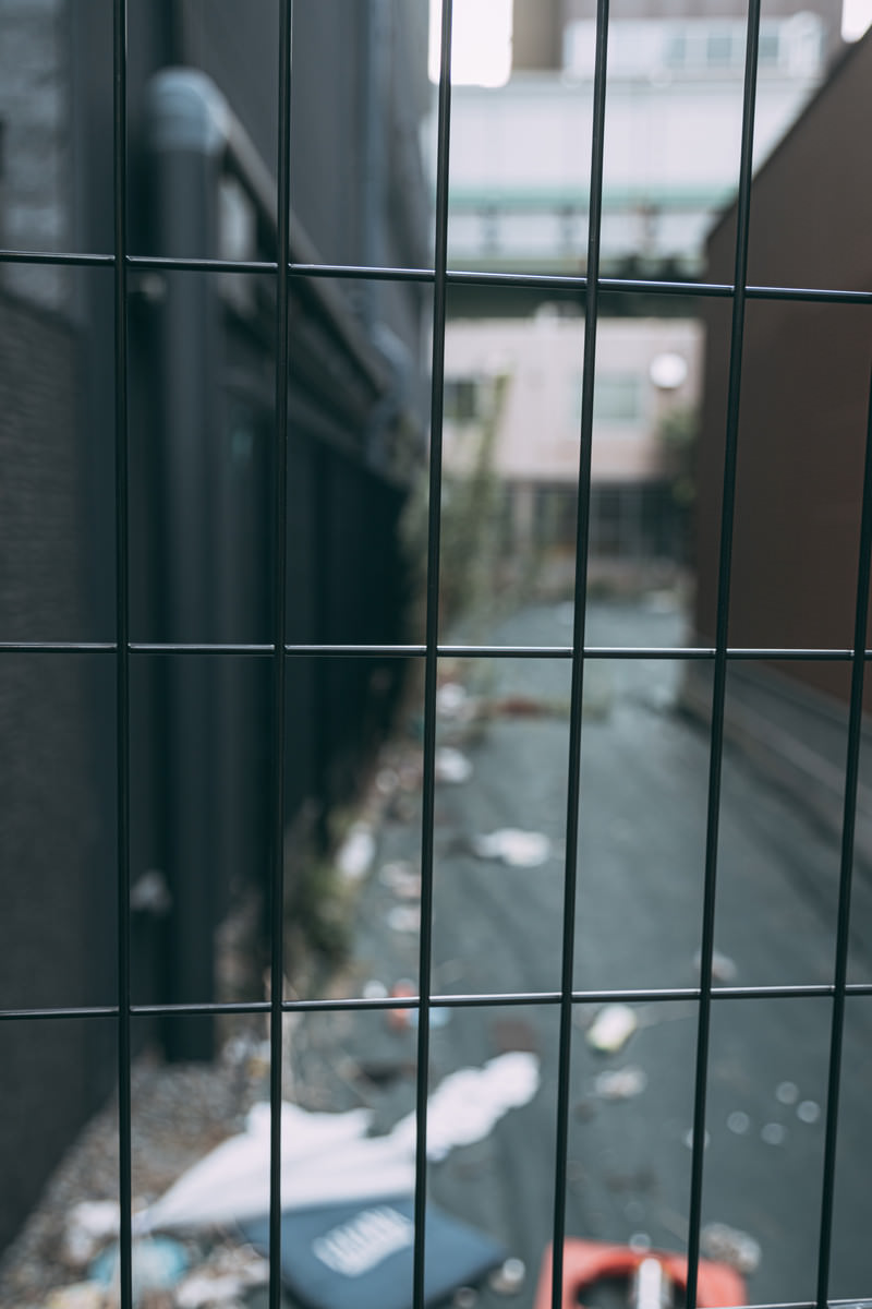 ゴミが散らかる路地裏のワイヤーフェンスの写真 画像 を無料ダウンロード フリー素材のぱくたそ