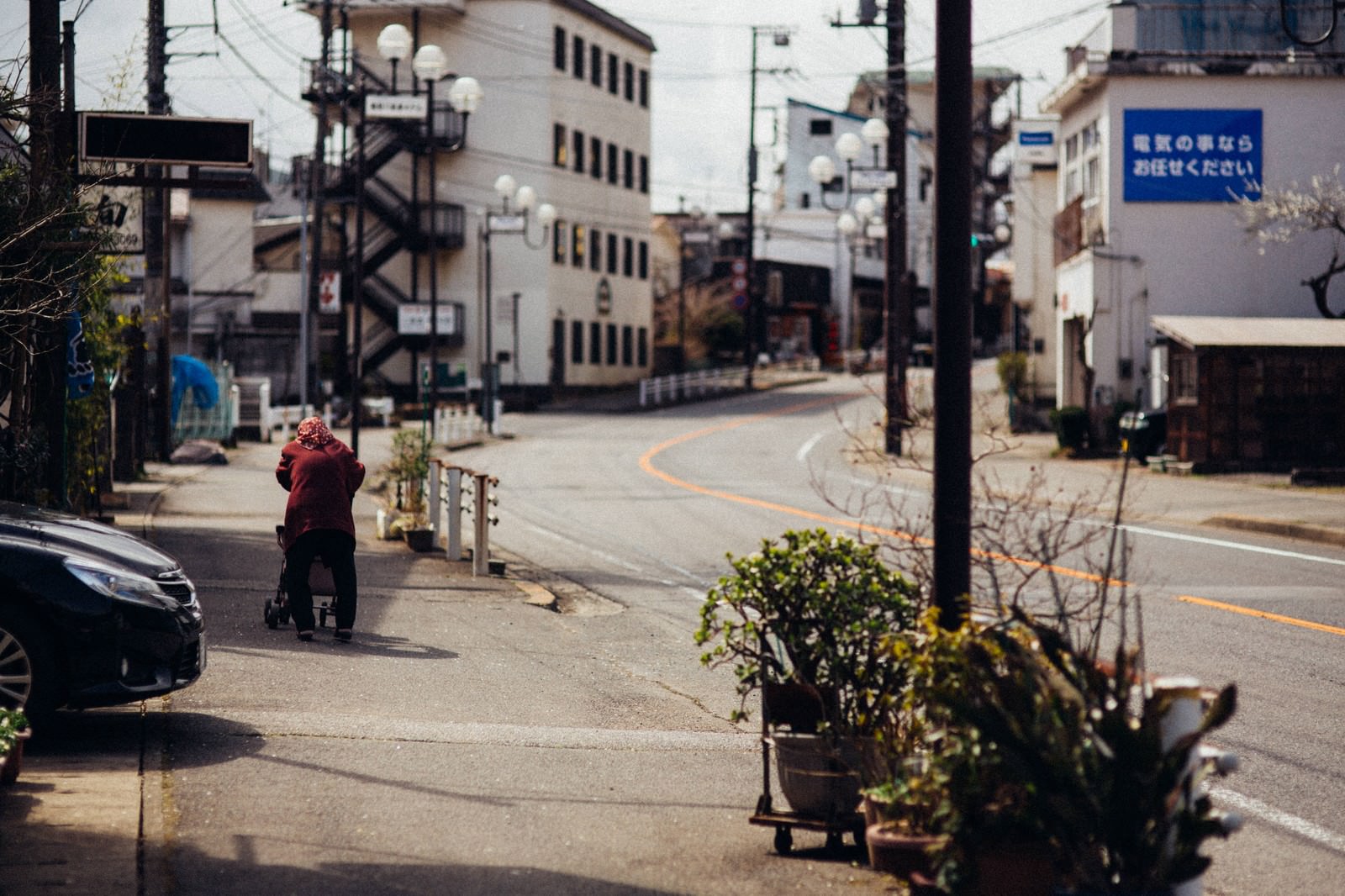 「閑散とした街と老婆の後ろ姿」の写真