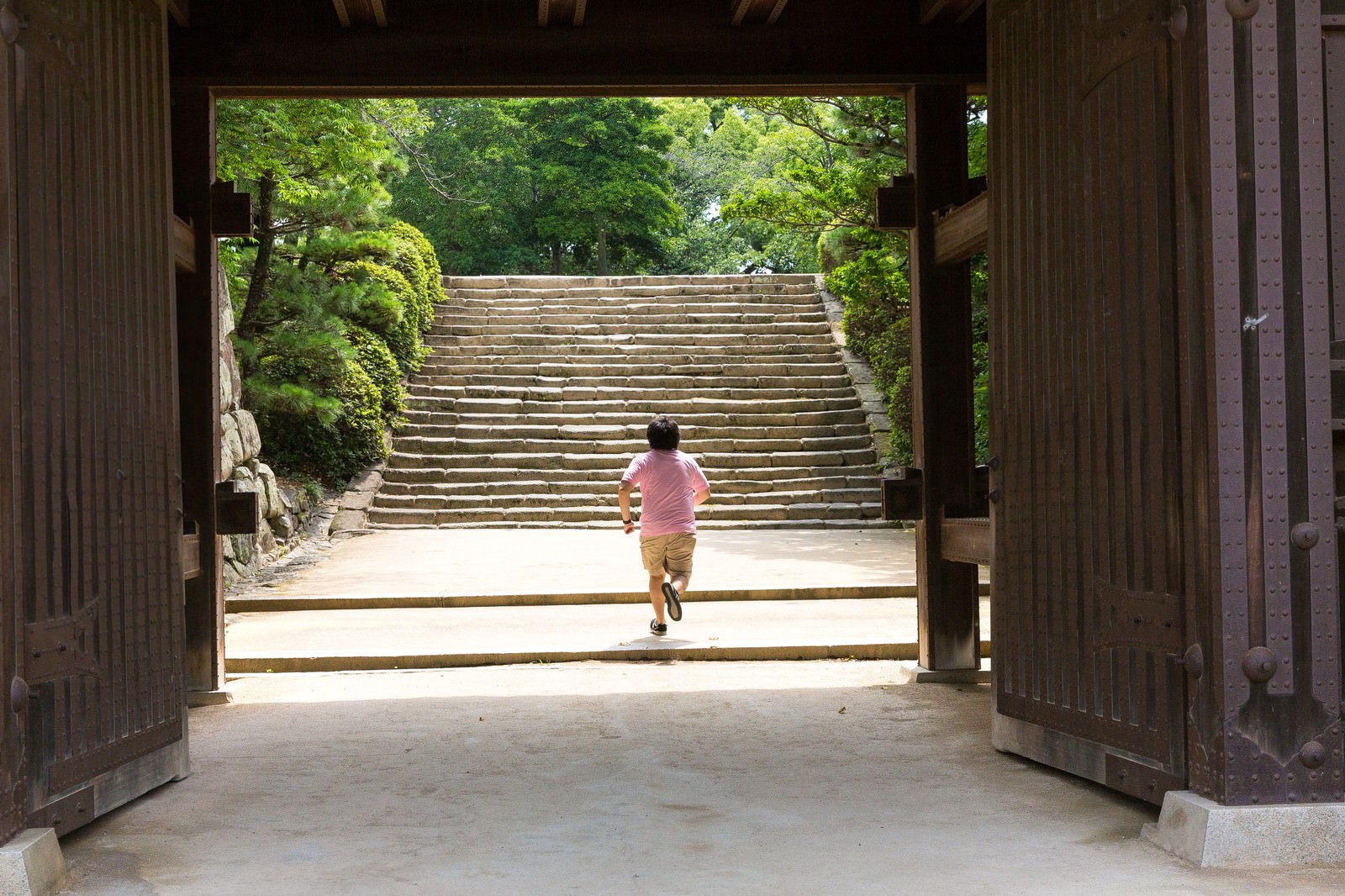 「城門（岡山城）を撮影中、走りだすAD | フリー素材のぱくたそ」の写真［モデル：あまのじゃく］