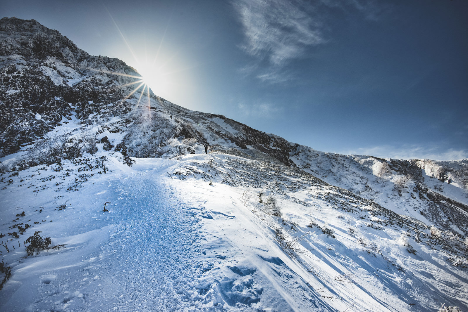 「稜線に差し込む光と登山者」の写真