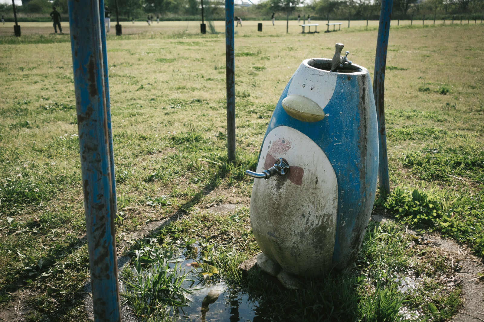 野球場の側にある廃れたペンギンオブジェの水道のフリー素材