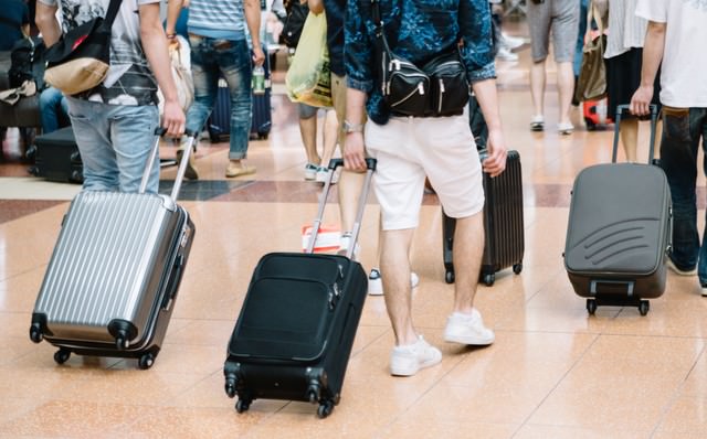 空港でキャリーバッグを持った観光客