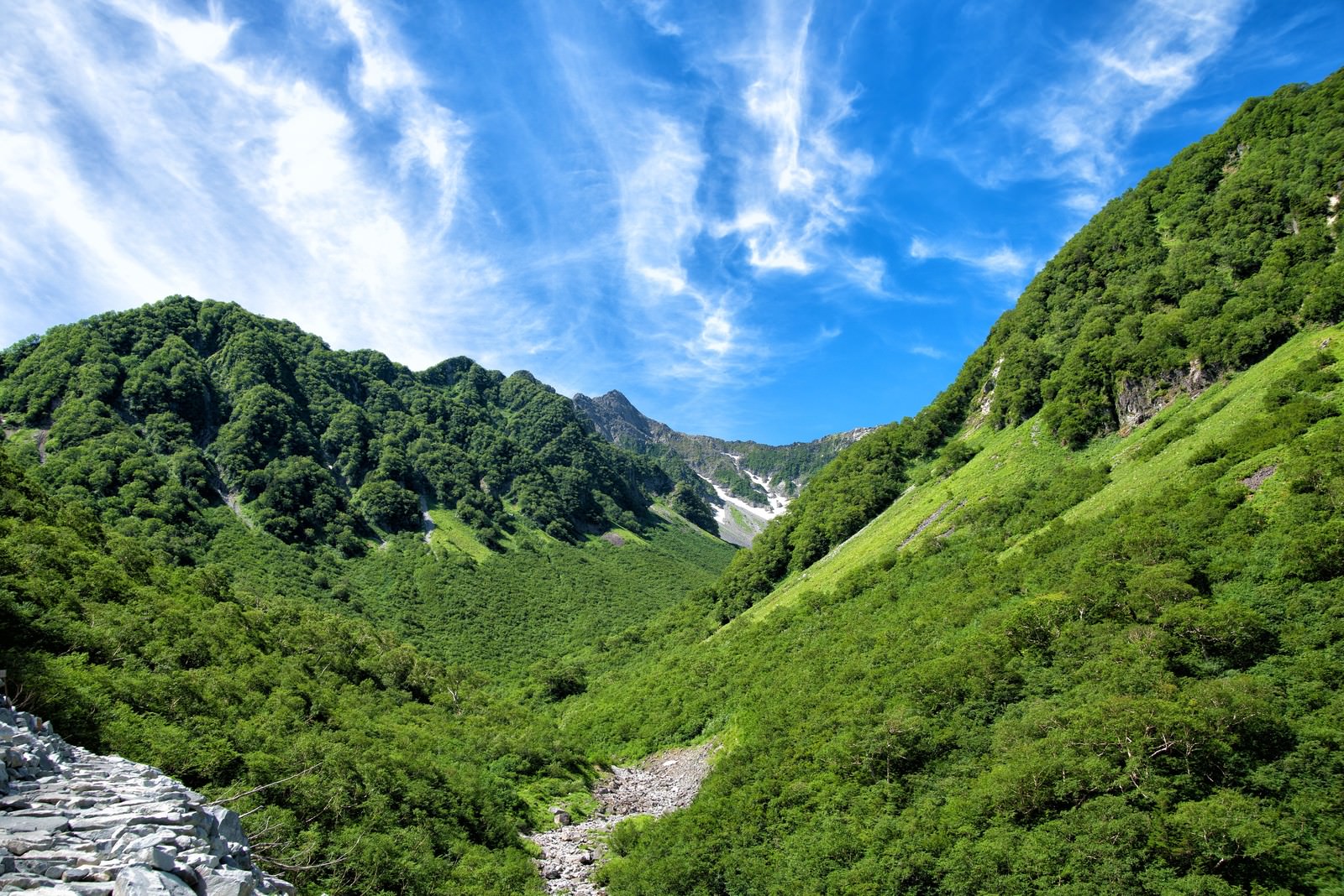 新緑溢れる山間からかすかに見える涸沢カールの写真素材 ぱくたそ