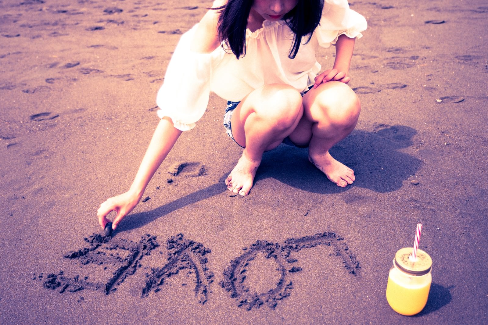 「砂浜に「LOVE」を書く女の子」の写真