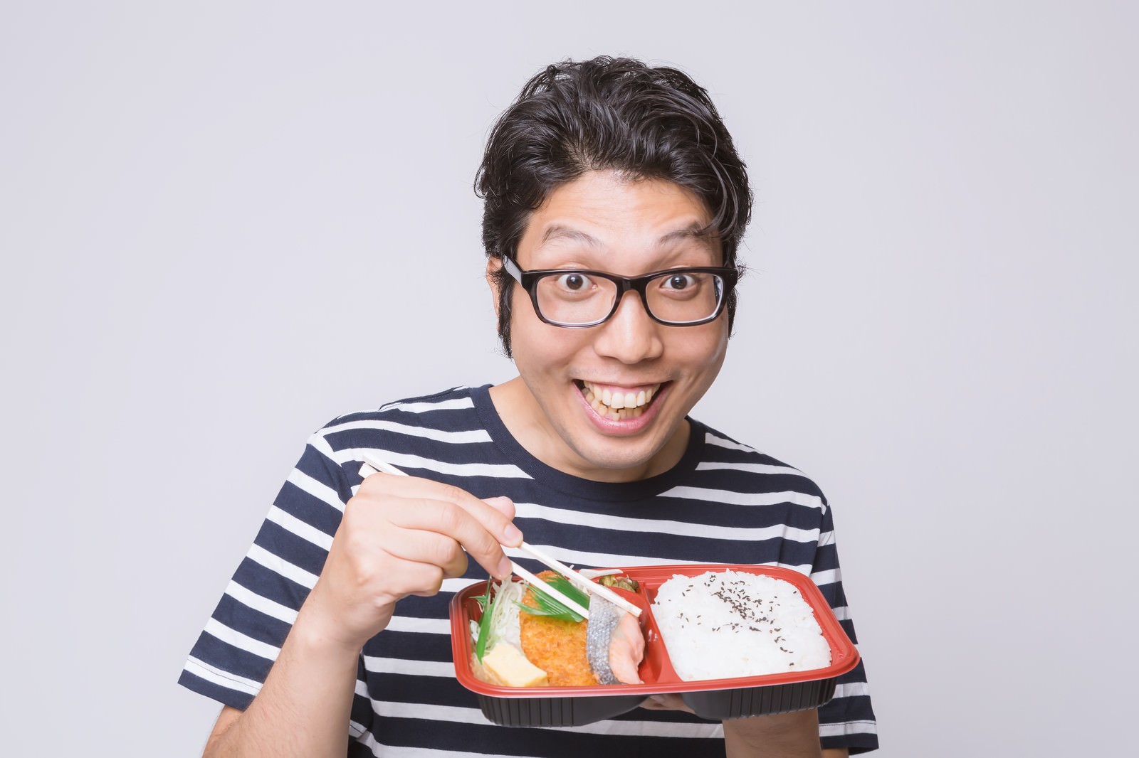 「喜んでお弁当を食べる男性」の写真［モデル：紳さん］