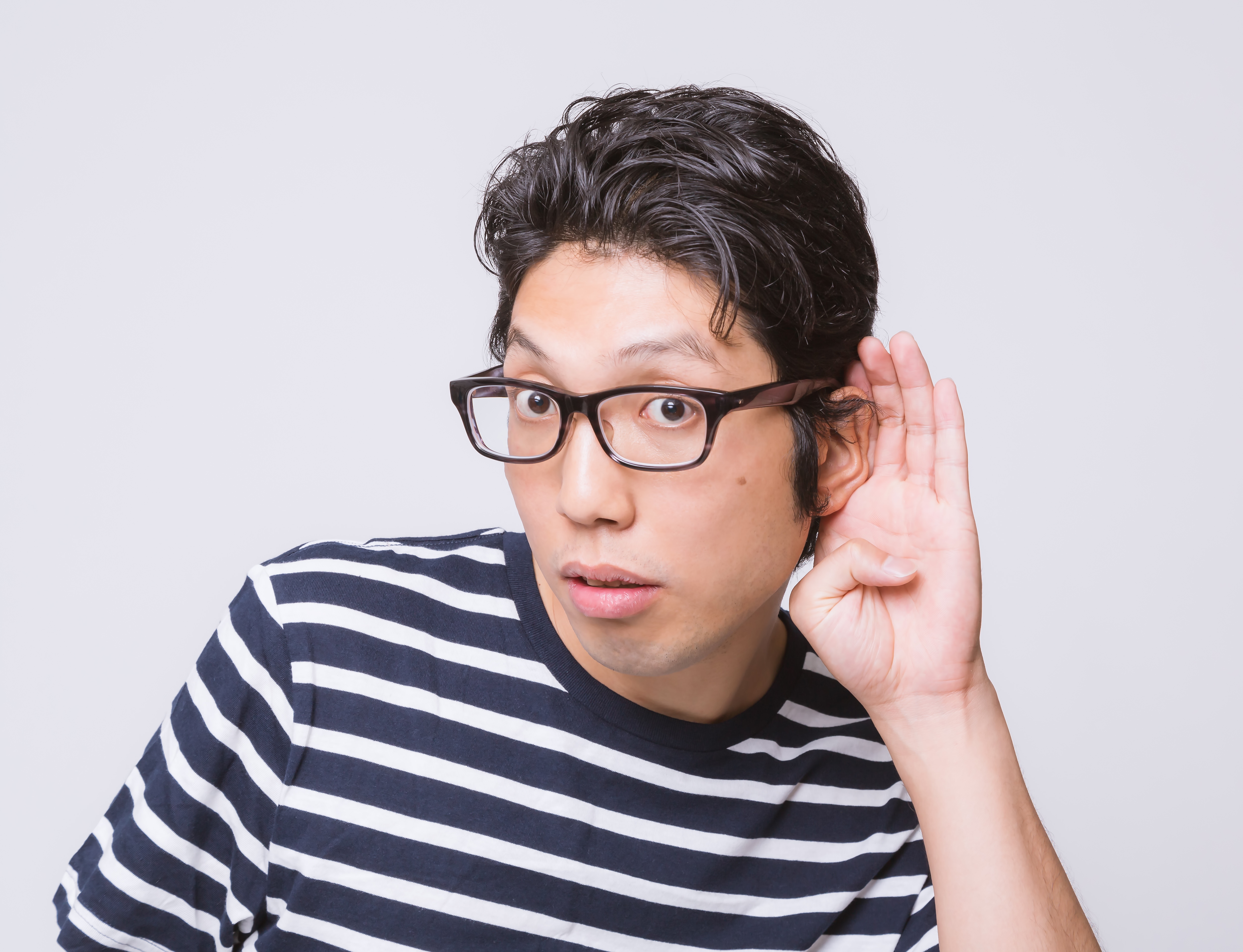 耳に手をあてる男性の写真素材 ぱくたそ