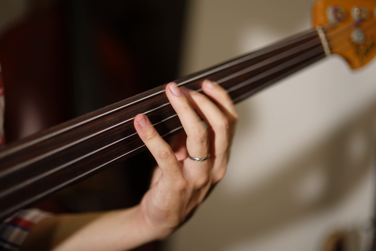 「ベースの4弦と左手」の写真