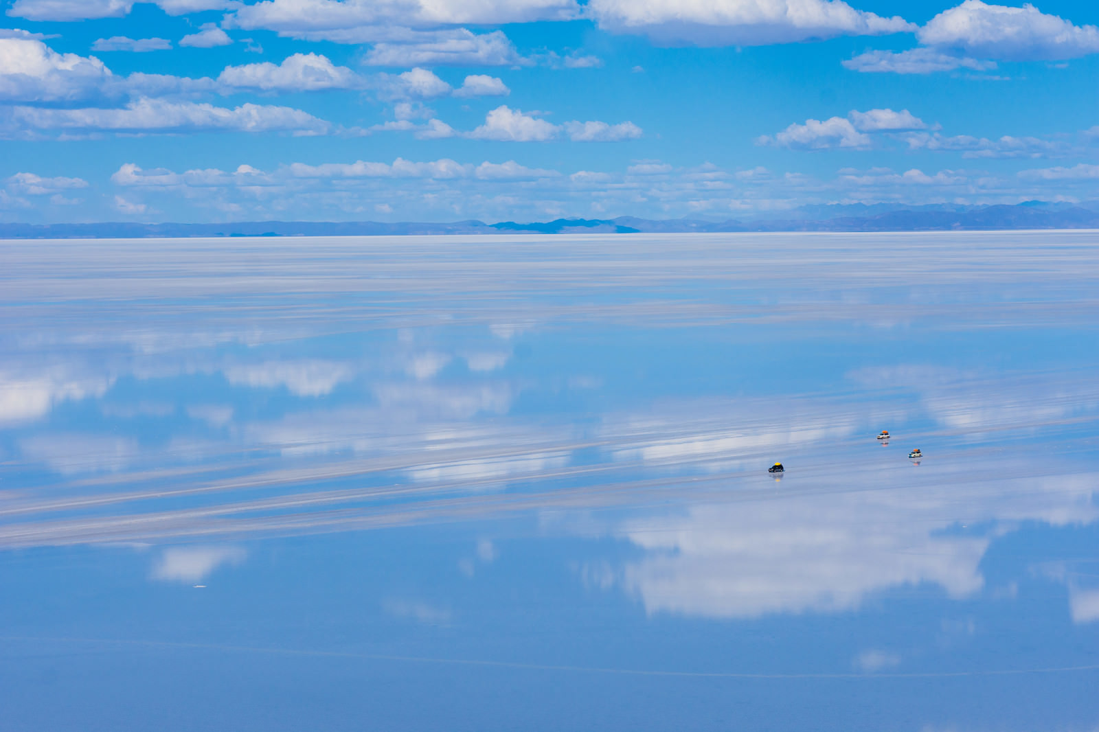 天空の鏡と呼ばれる雨季のウユニ塩湖を横断する車の写真 フリー素材は ぱくたそ 写真を無料ダウンロード