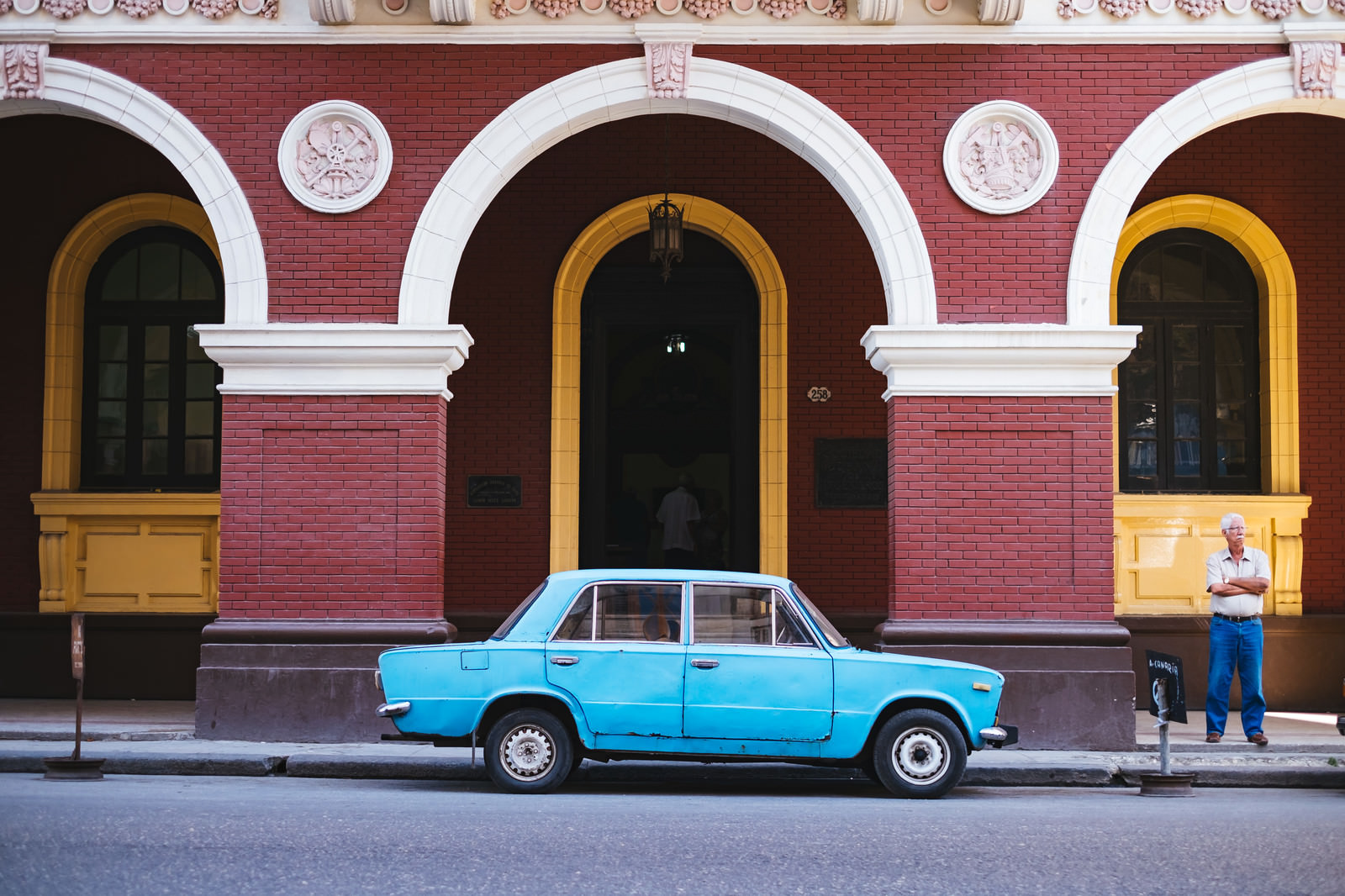 「建物の前に駐車中の青い車（キューバ）」