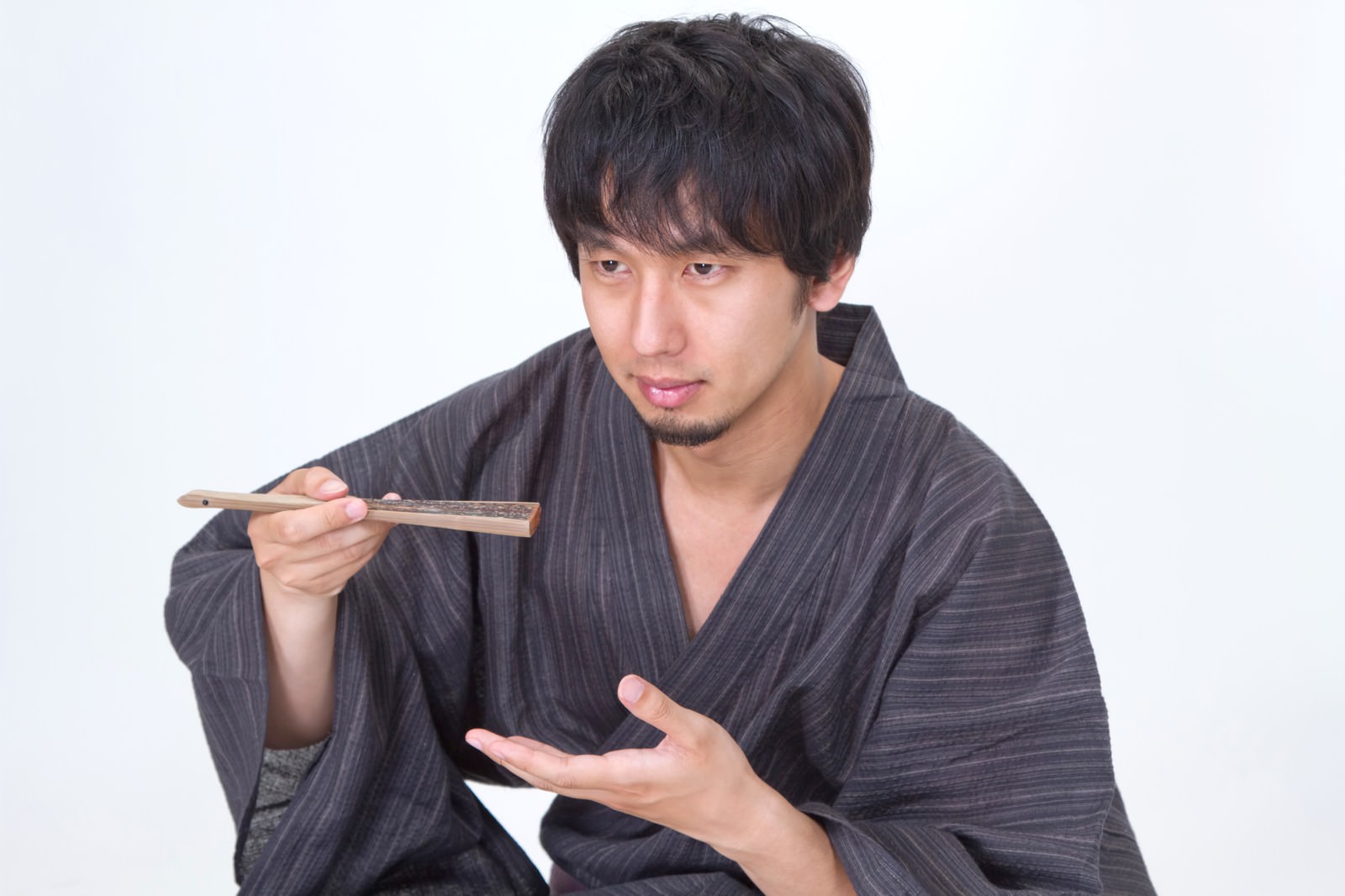 「扇子を使って何かを食べる浴衣男子 | フリー素材のぱくたそ」の写真［モデル：大川竜弥］