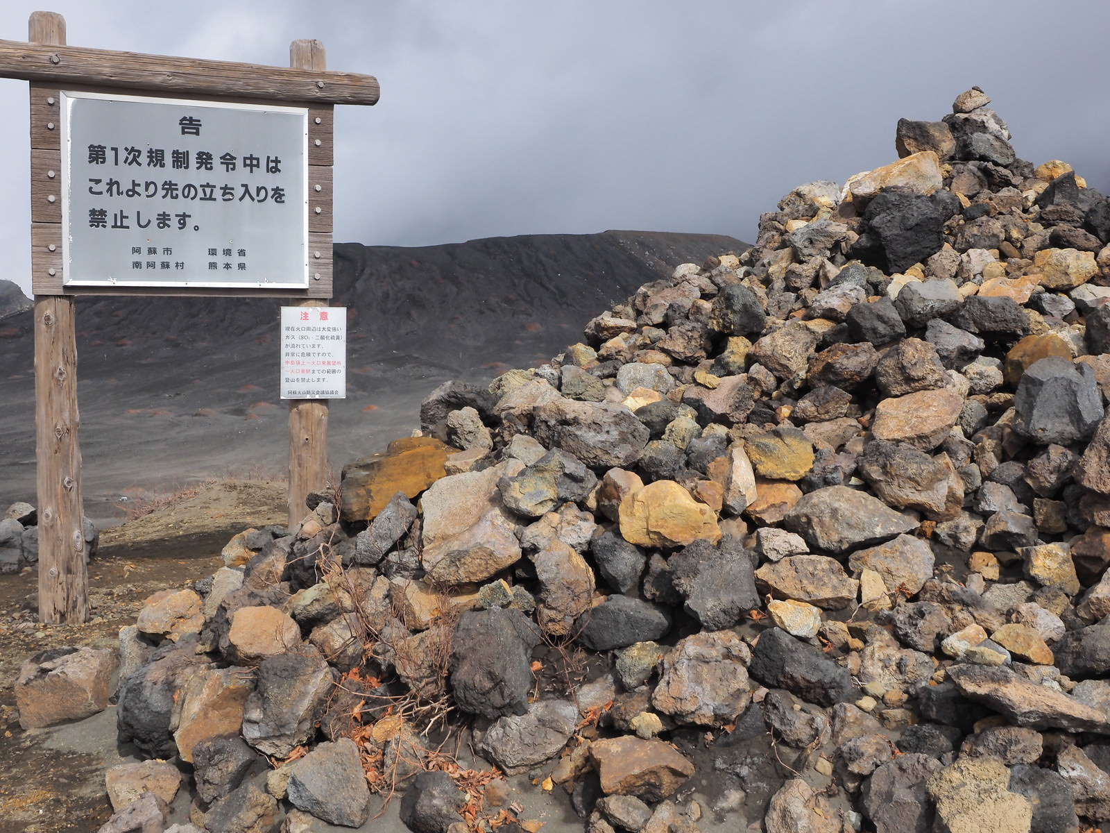 「阿蘇山の積まれた岩石と立ち入り禁止の看板 | フリー素材のぱくたそ」の写真