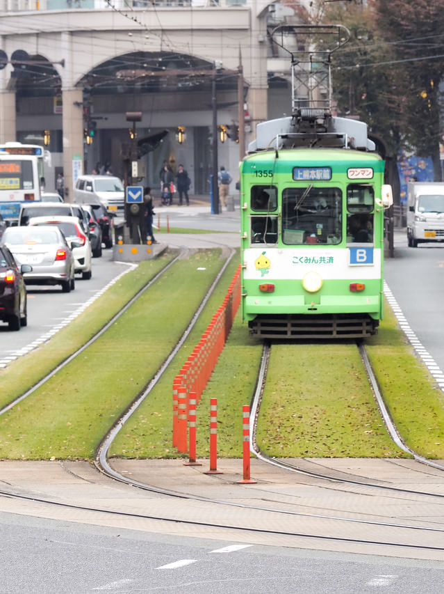 「緑化された路線を走る熊本市電(路面電車)」のフリー写真素材