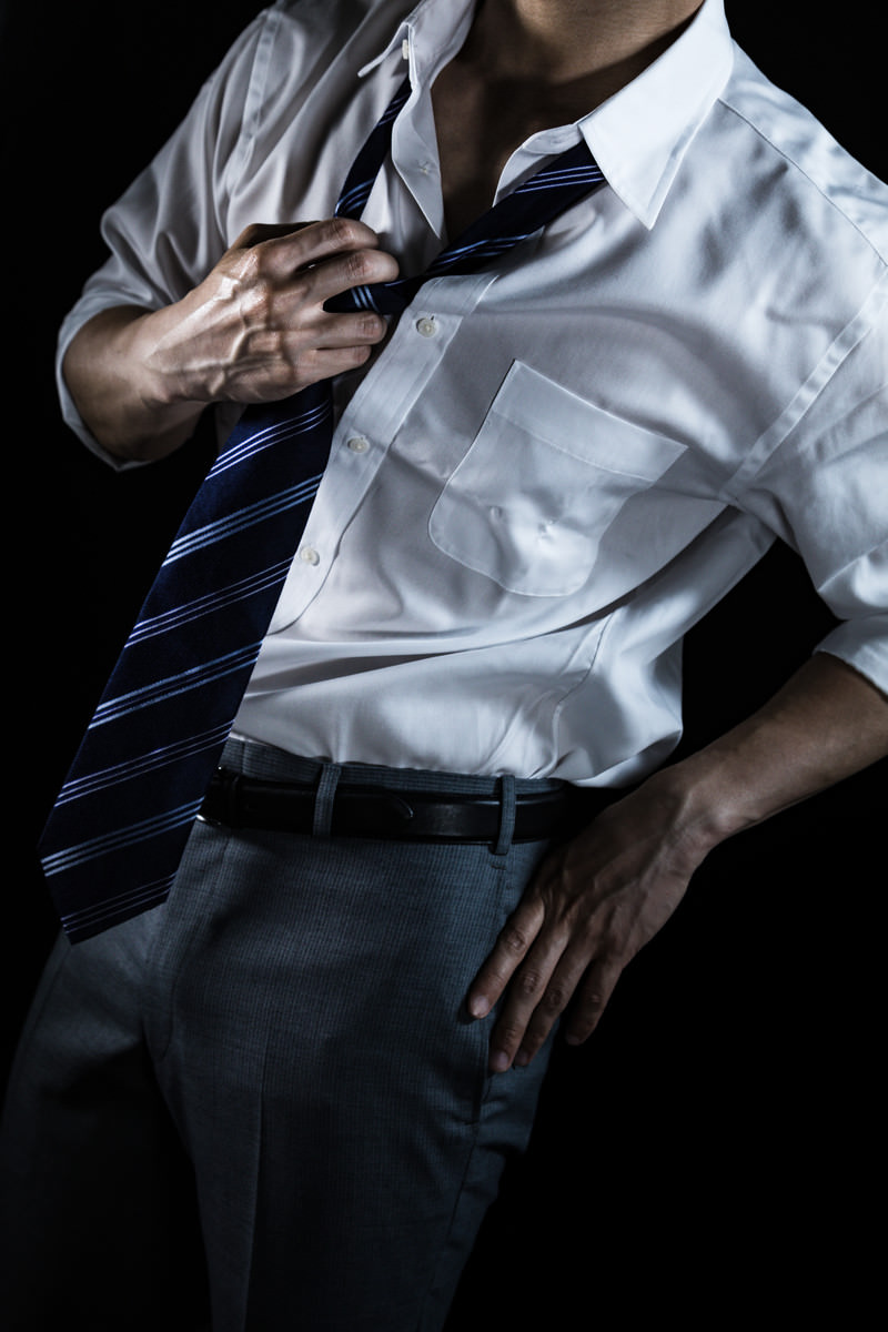 「ネクタイを緩めるスーツ姿の男性（クールビズ） | フリー素材のぱくたそ」の写真［モデル：大川竜弥］