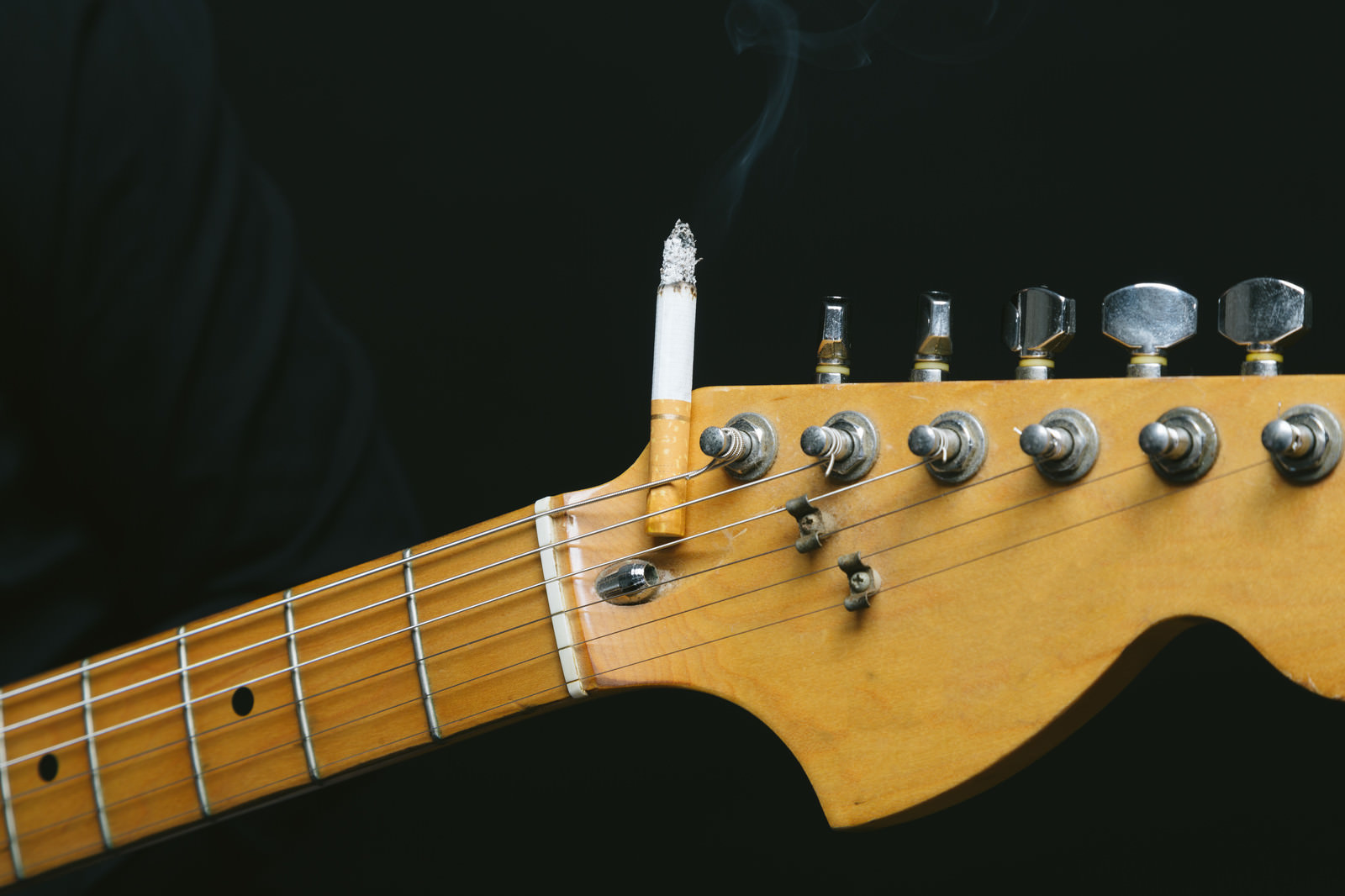 「ギターのヘッドにタバコを挟む（焦げあと注意）」の写真
