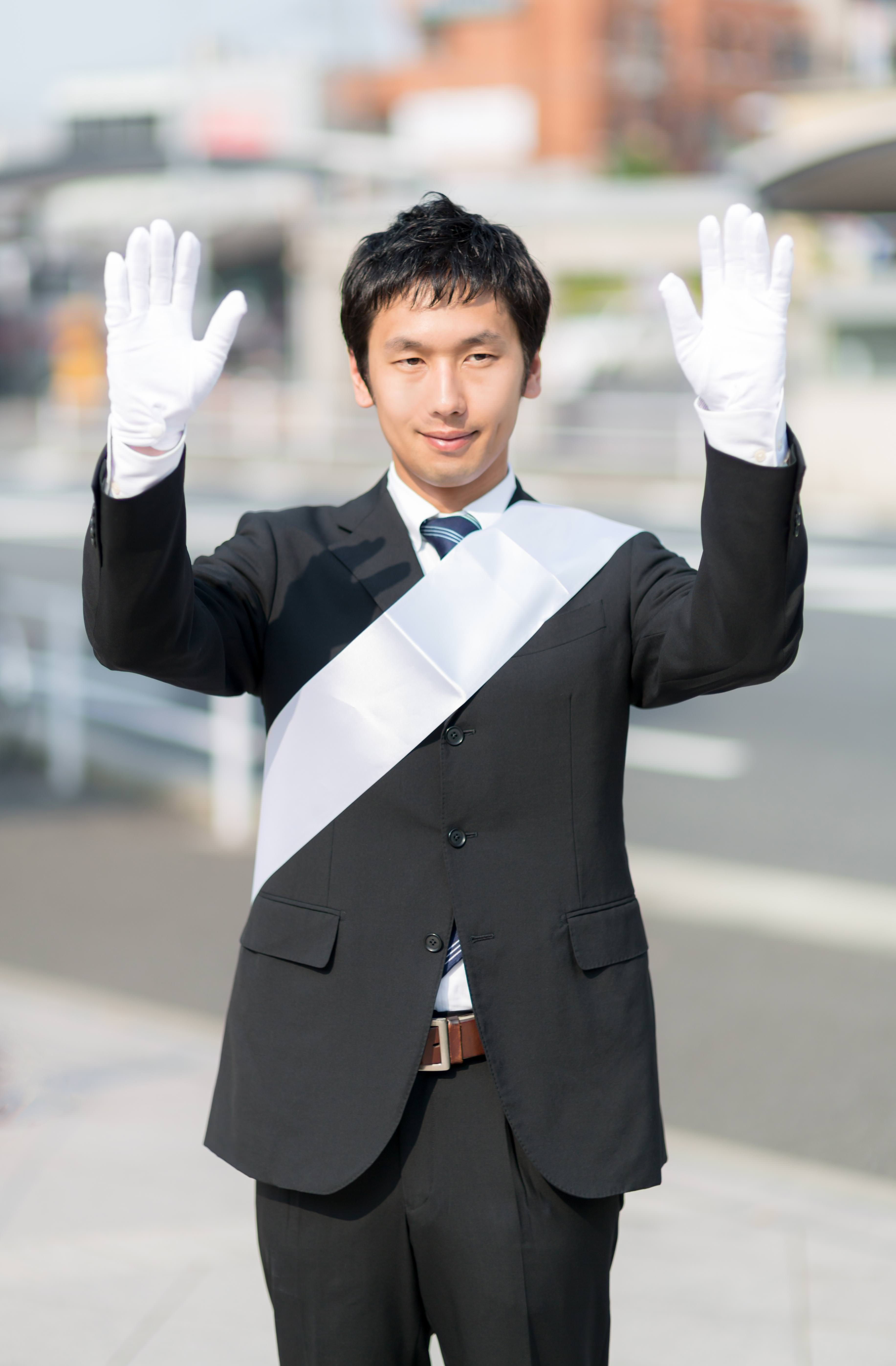 両手をあげて支援を呼びかける党公認候補の写真素材 ぱくたそ