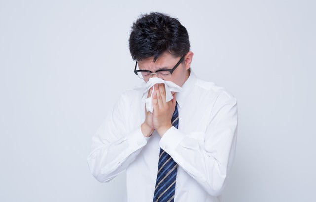 花粉症で鼻をかむ男性