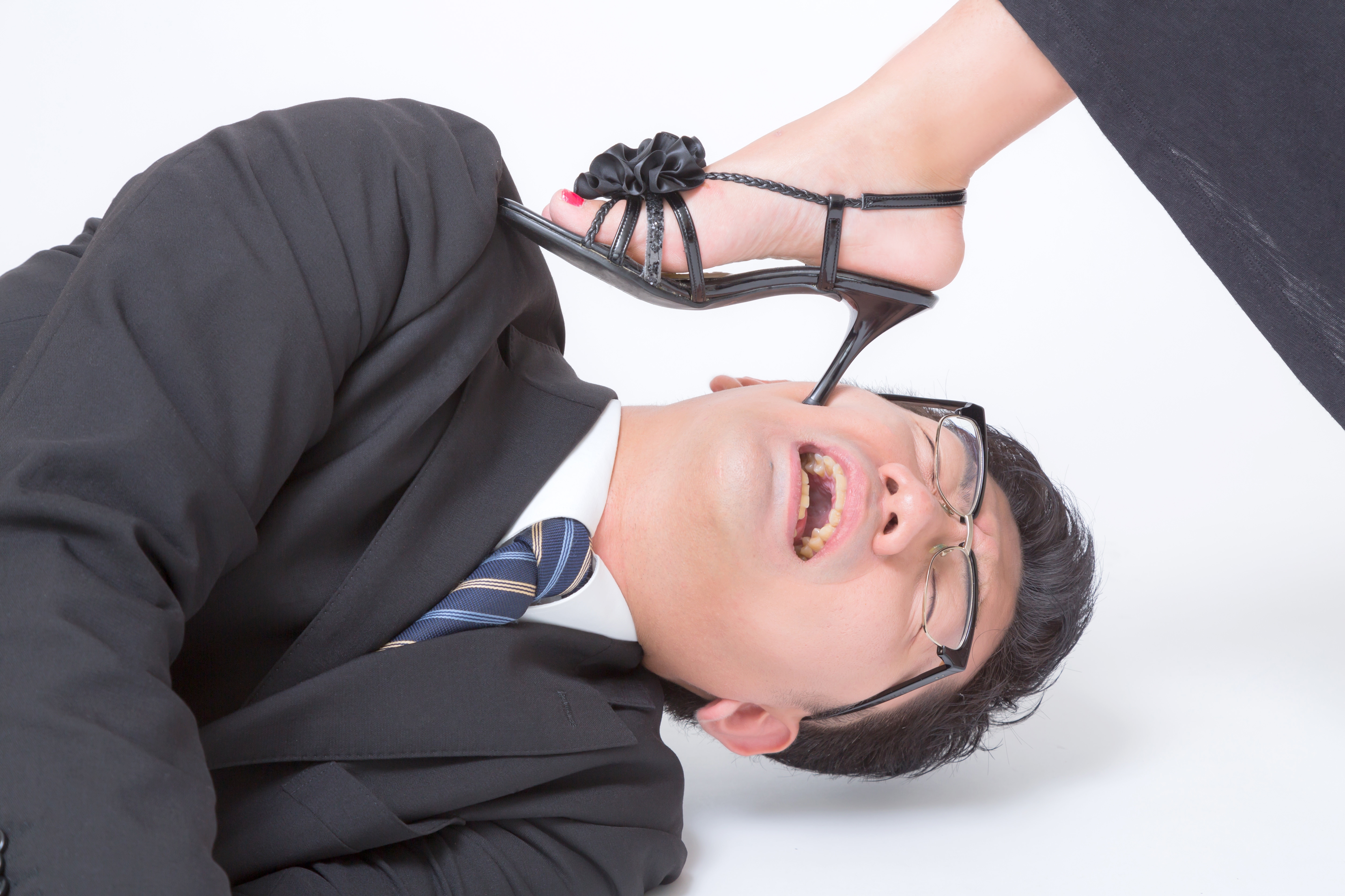 寝落ちしている社員を踏みつけて起こすの写真素材 ぱくたそ