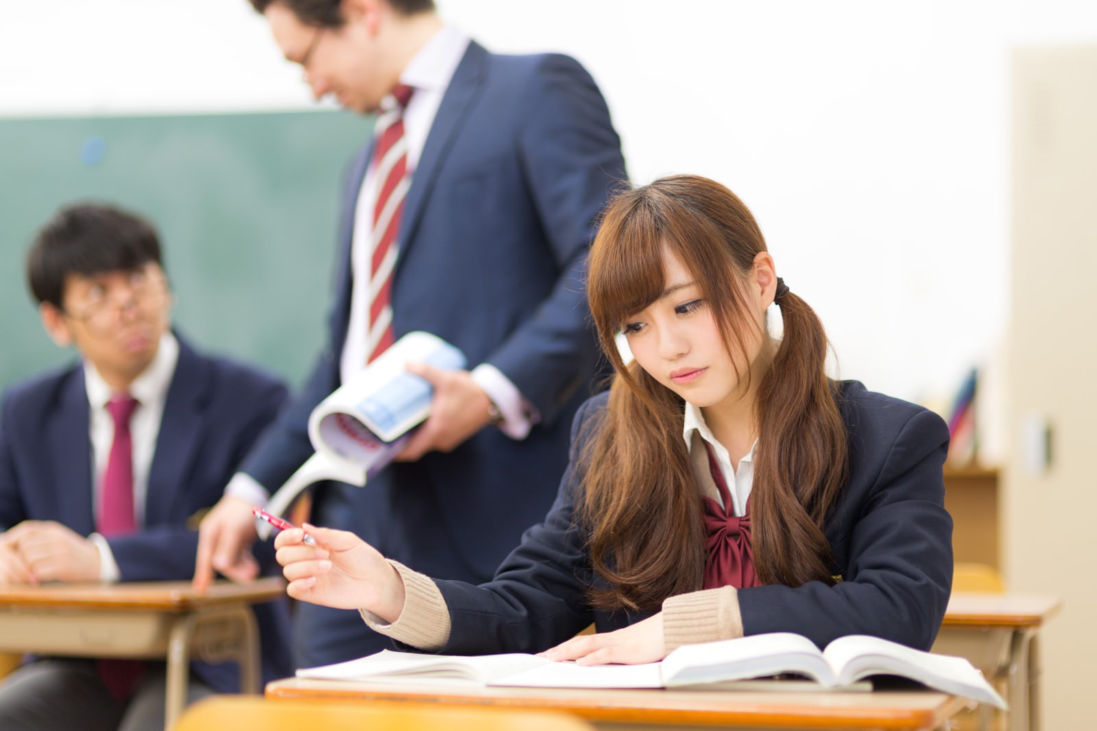 「真面目に授業をうける女子高生と崩壊気味の男子高生」の写真［モデル：河村友歌 Max_Ezaki 大川竜弥］