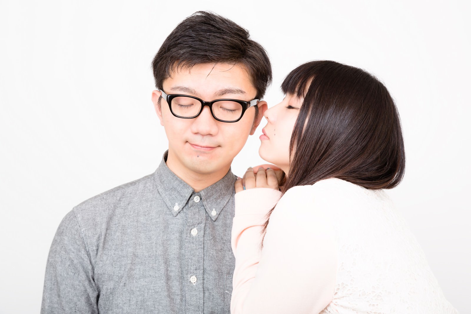 「ほっぺたにキスをしようとする彼女と穏やかな表情の彼氏」の写真［モデル：OZPA Lala］