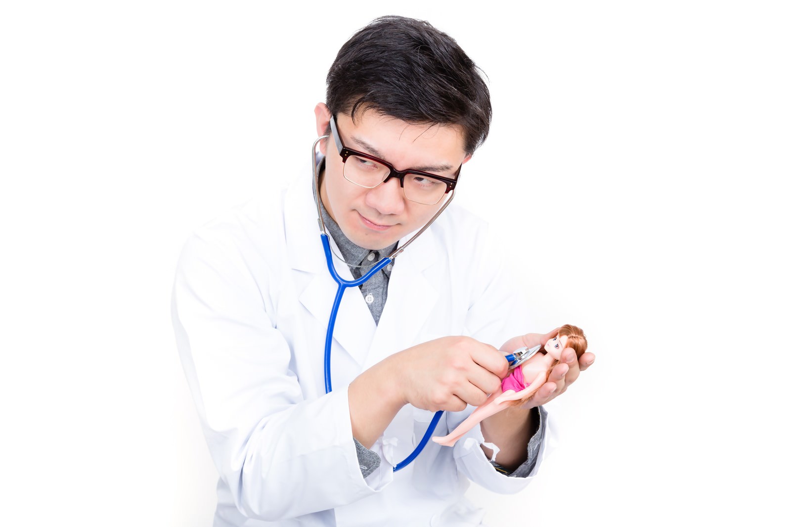 「人形に聴診器を当ててお医者さんごっこをする男性 | フリー素材のぱくたそ」の写真［モデル：OZPA］
