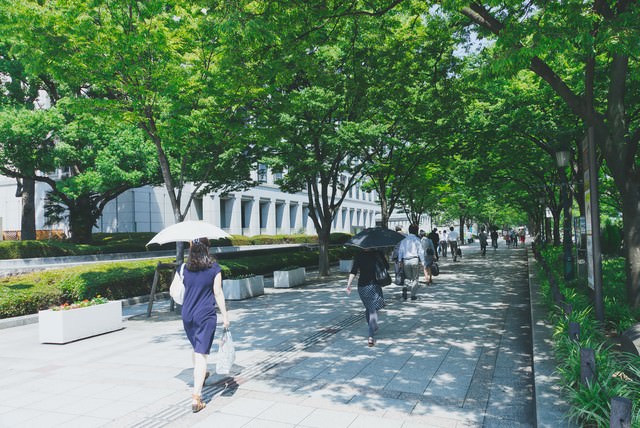 緑の多い通りと出勤する人たち