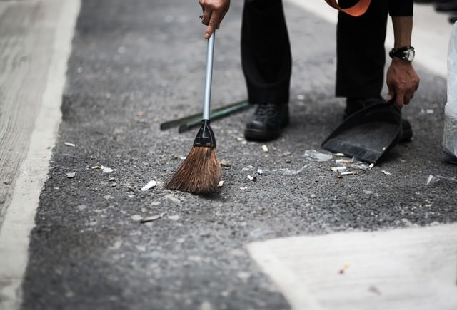 渋谷の街をチリトリとホウキで清掃する人