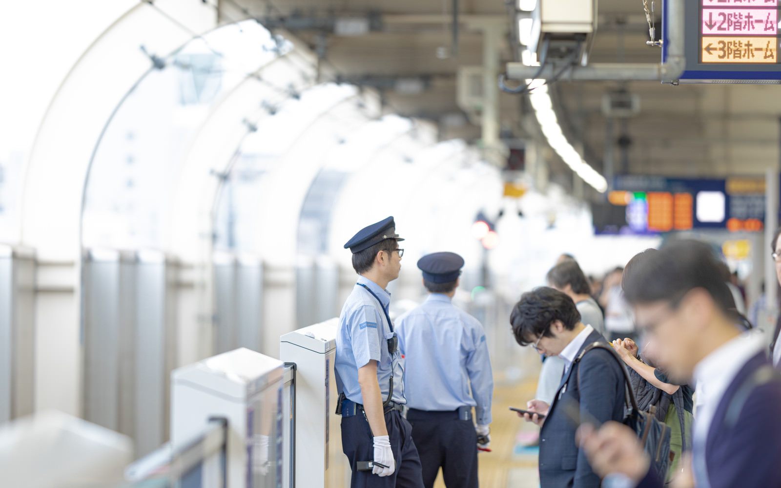 「電車を待つ人と駅員」の写真