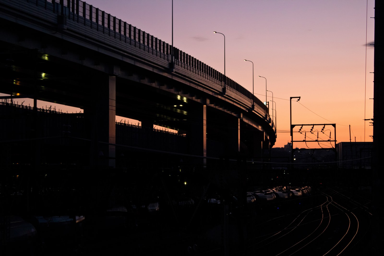 「夕暮れの高架と線路 | フリー素材のぱくたそ」の写真