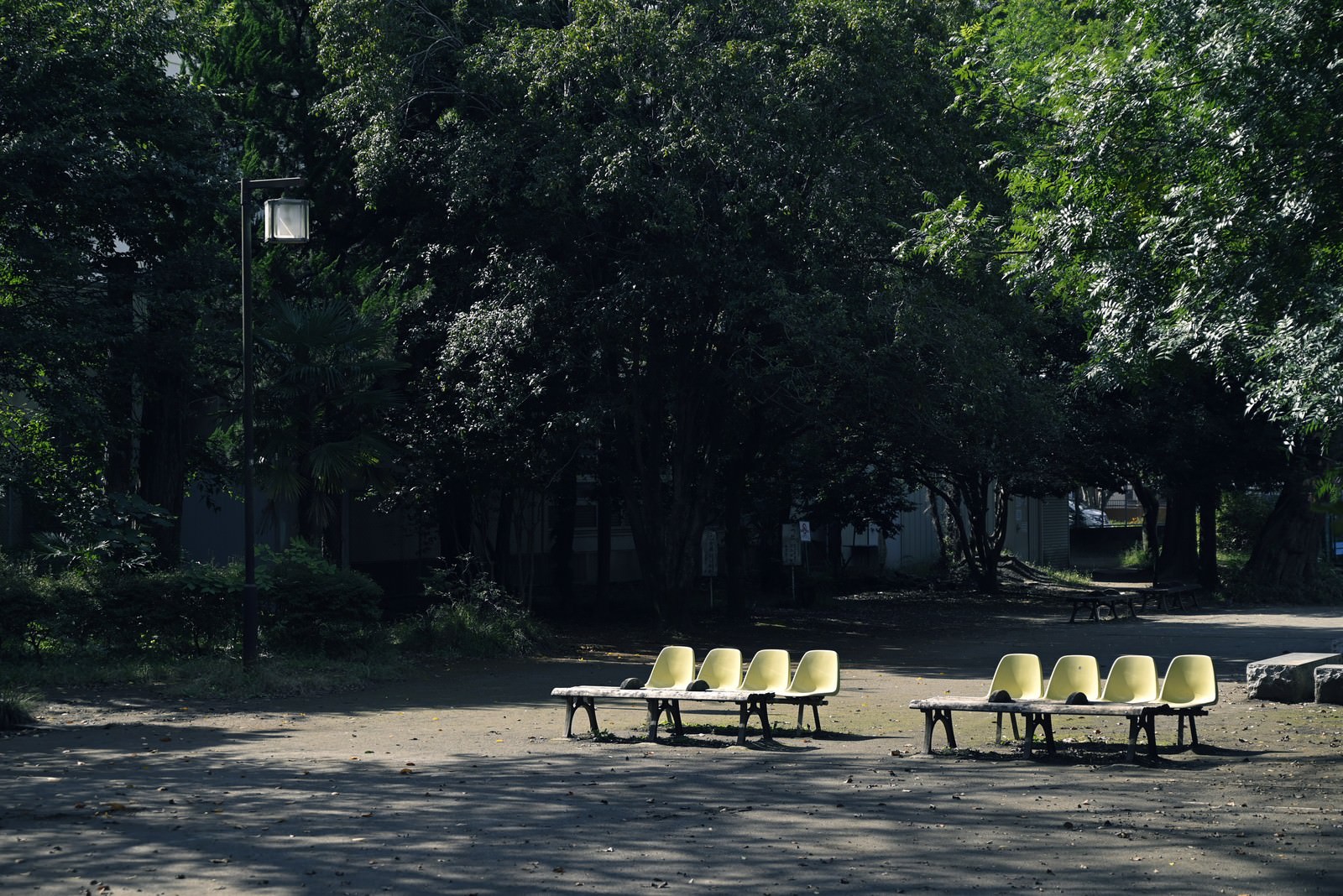 「誰もいない寂しい昼の公園のベンチ | フリー素材のぱくたそ」の写真