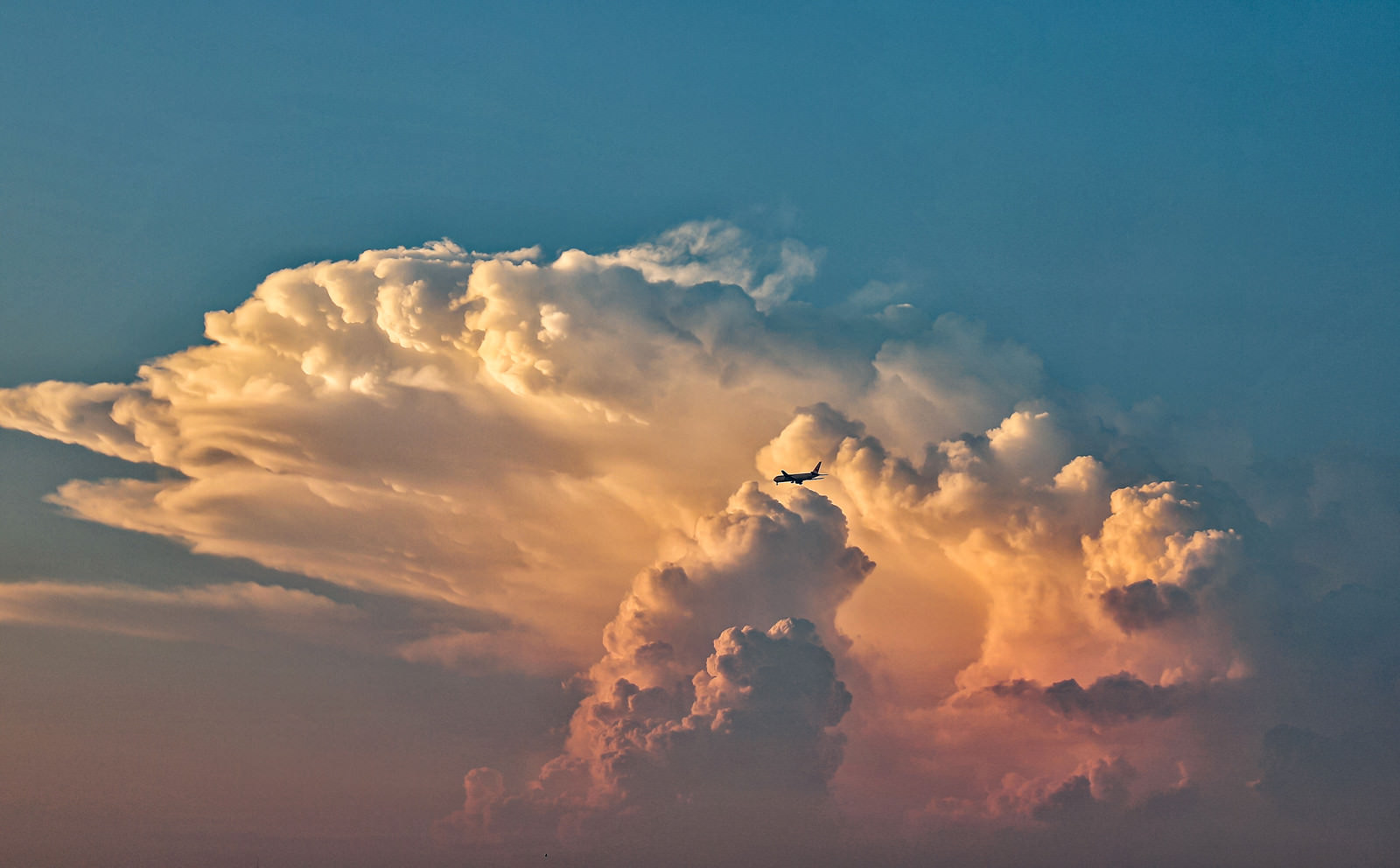 夕焼けに染まる入道雲と飛行機の写真素材 ぱくたそ