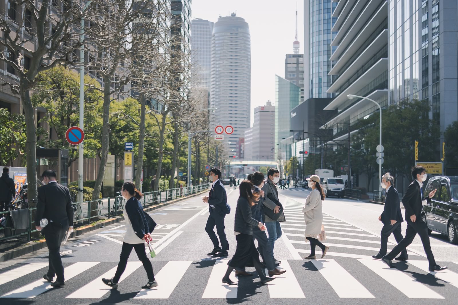 「オフィス街の横断歩道を渡る人たち」の写真